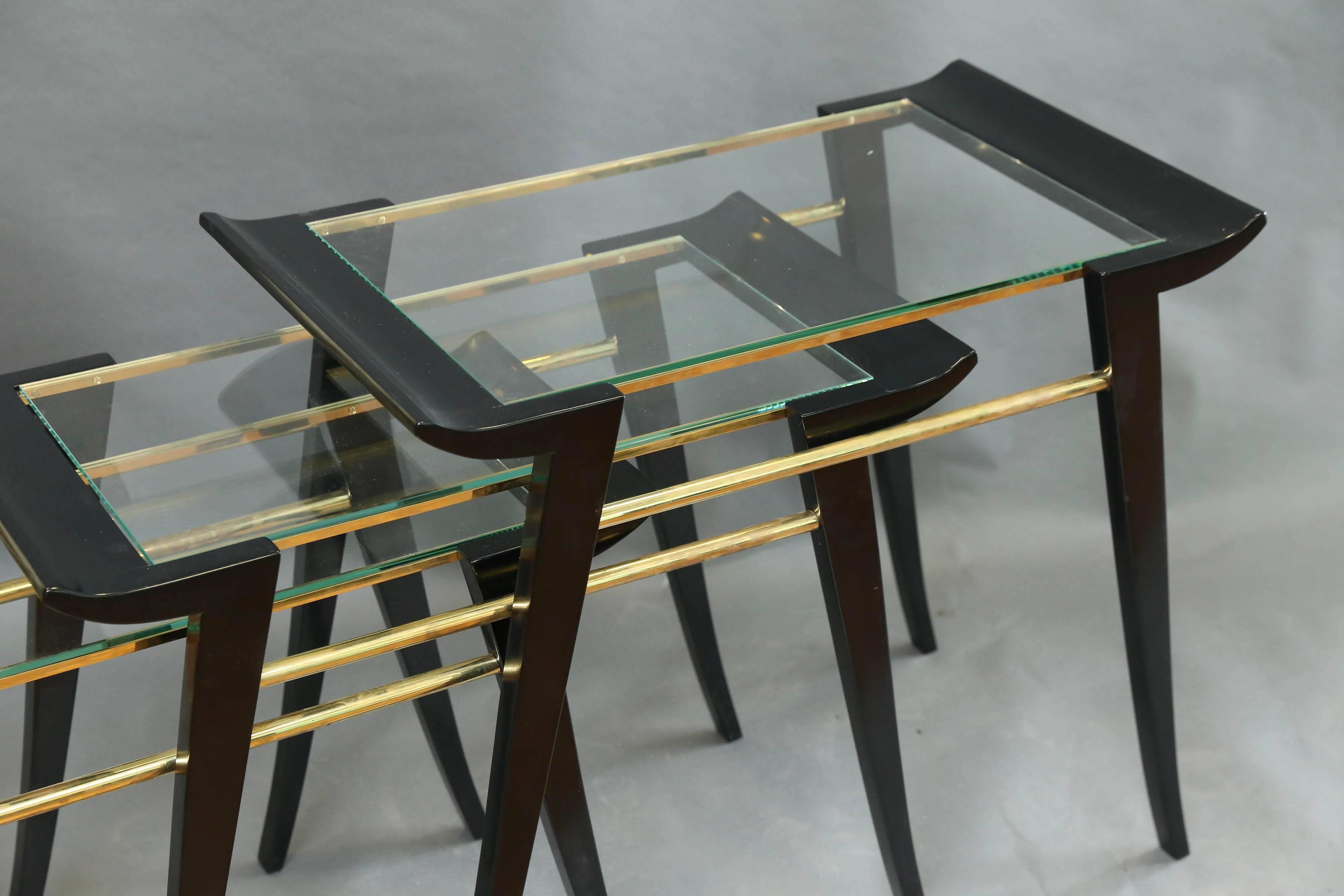 Side tables are made out of ebonized walnut wood. Table tops are made out of glass, which are wrapped in curved wood on two sides. Each of the tables is elevated by four wooden legs and one table fits under another. 

Condition is perfect.