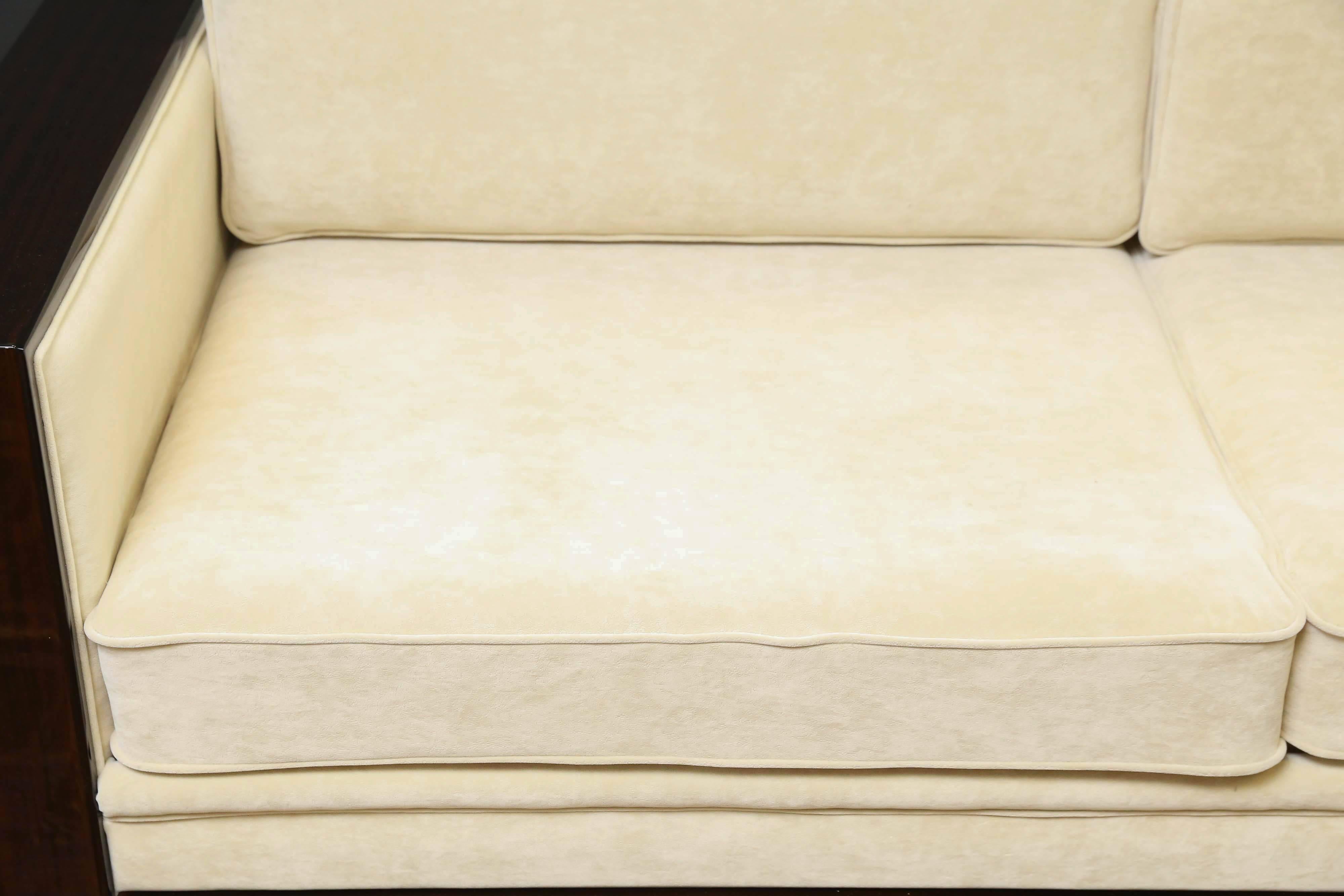 The base of the sofa is made out of Fine walnut wood. It is re-upholstered in a light yellow fabric. It has two pairs of pillows and wide wooden arm rests. The thickness of pillows provide very good back support. 
Condition is excellent. 

