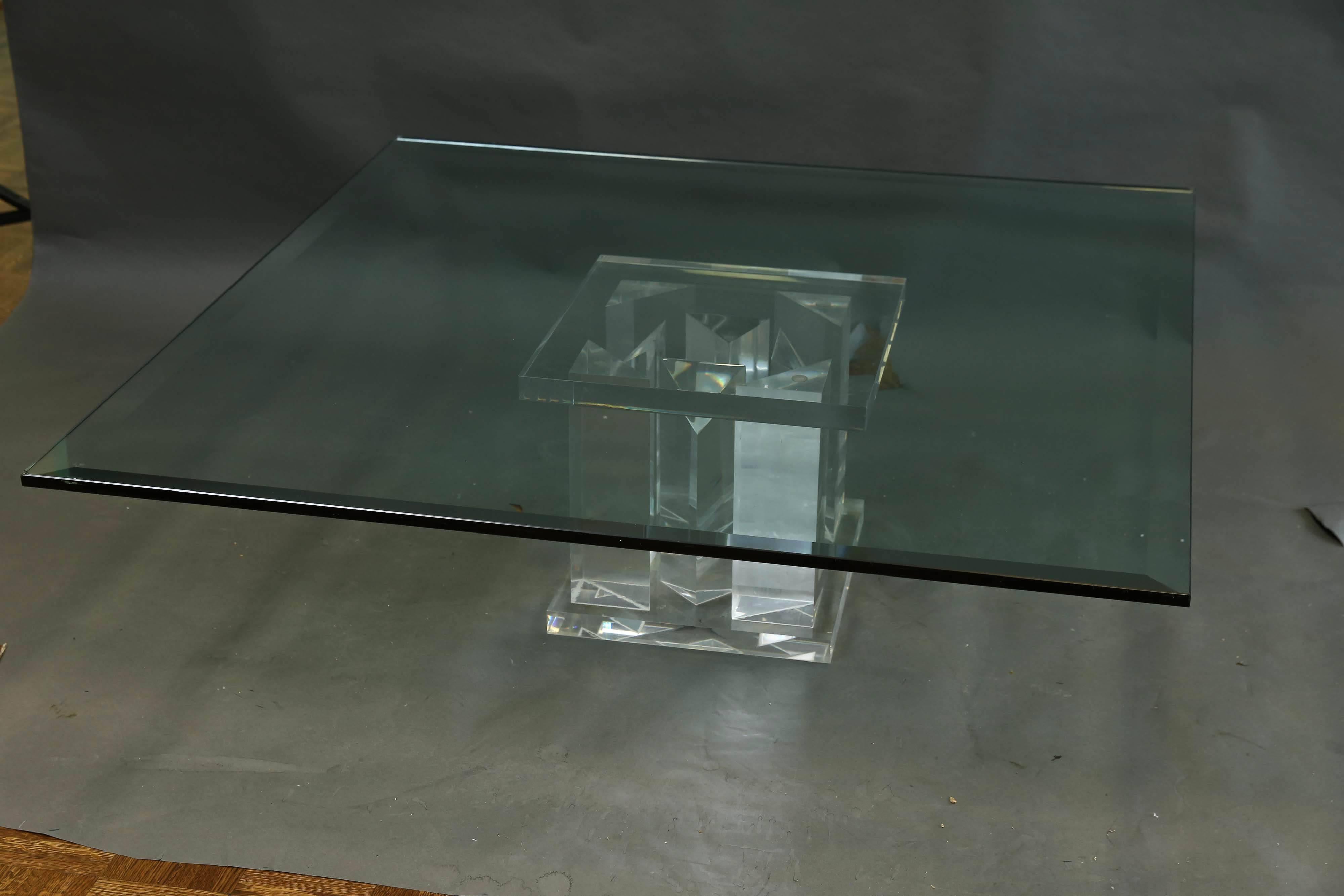 Coffee table’s top is made out of thick piece of glass. Supporting base is made out of plexiglass and composed from four rectangular elongated pieces. Due to transparent material, that the table is made out of, it looks very light, despite its size.