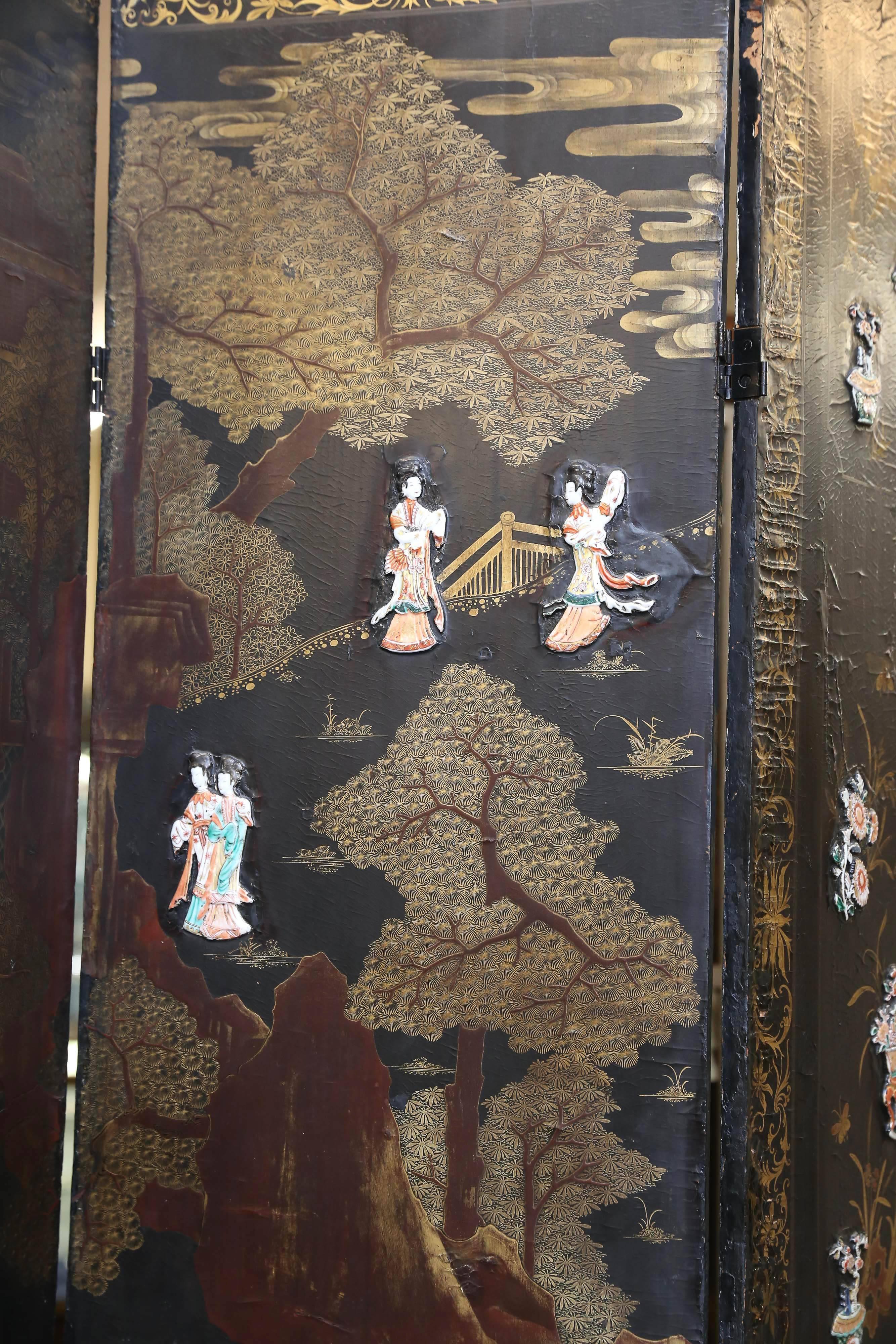 Beautiful screen is decorated with a flora and fauna hand-painted patterns that are emerging from the dark background. In the middle part of the screen on the foreground there are female porcelain painted figures that are arranged in the continuing