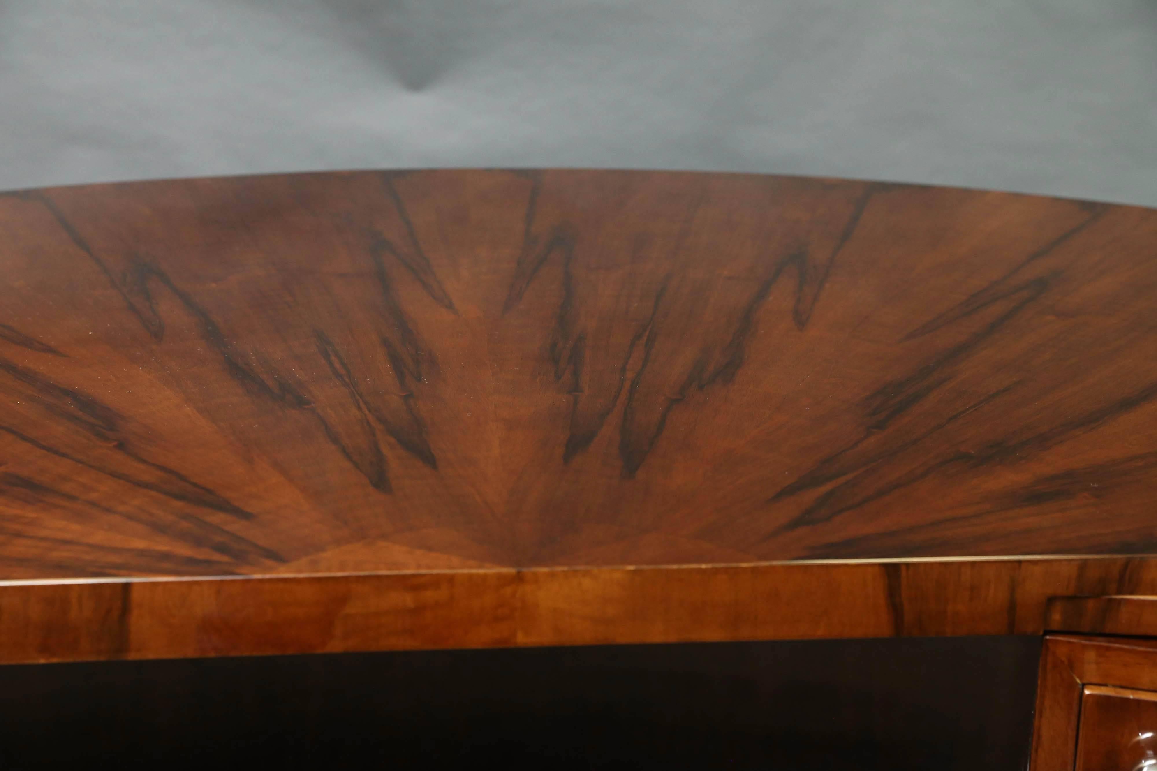 The desk is made out of high quality walnut wood. The tabletop is showing a beautiful design of wood, bursting sun rays. 
 On the right side of the desk there is one big drawer, on the left four smaller drawers. For the extra convenience, there are