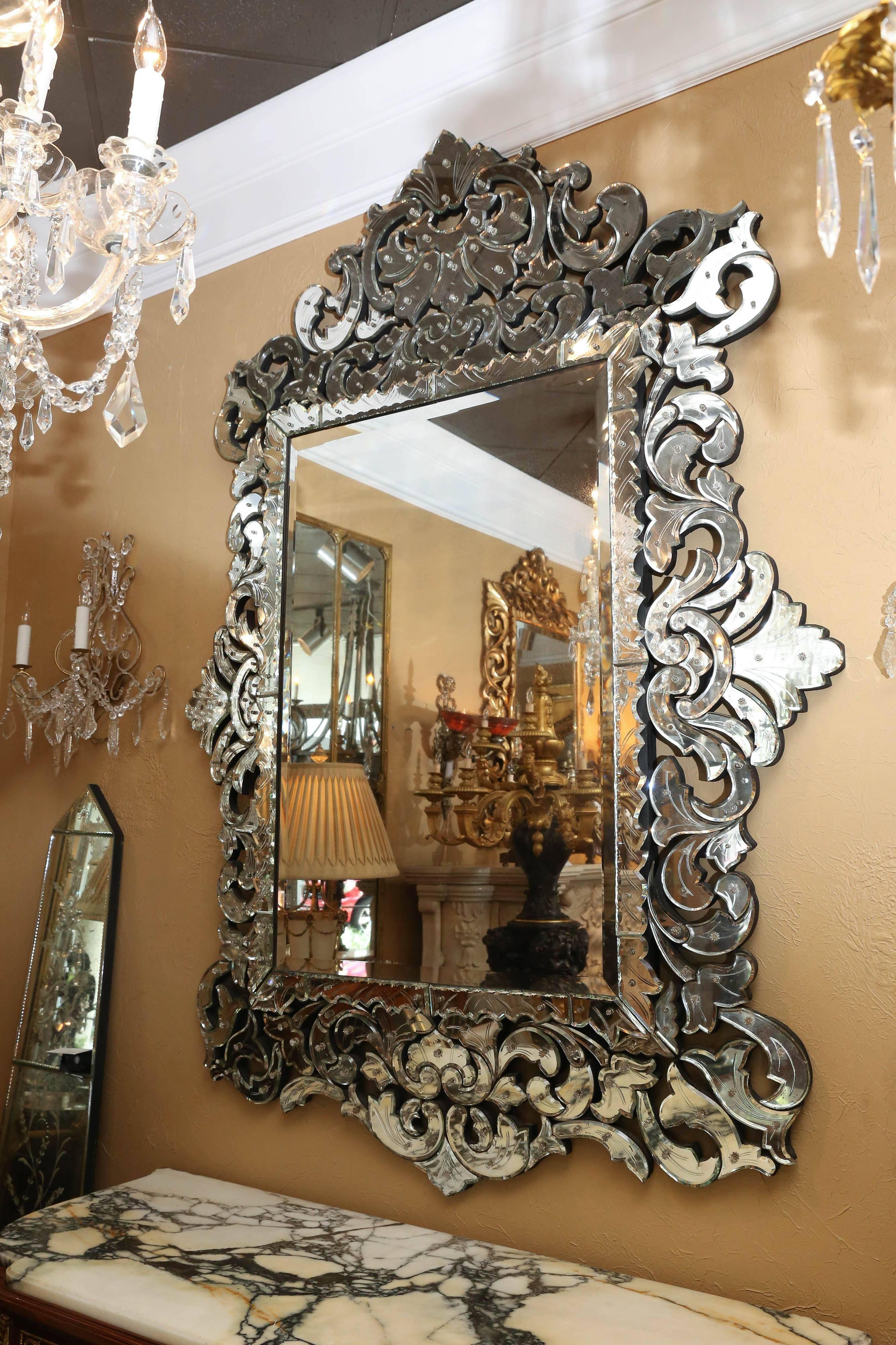 20th century, Italian, with segmented mirrored surround decorated with 
Engraved sprays of scrolls in various shapes. With a serpentine crest,
Sides and corner panels.
