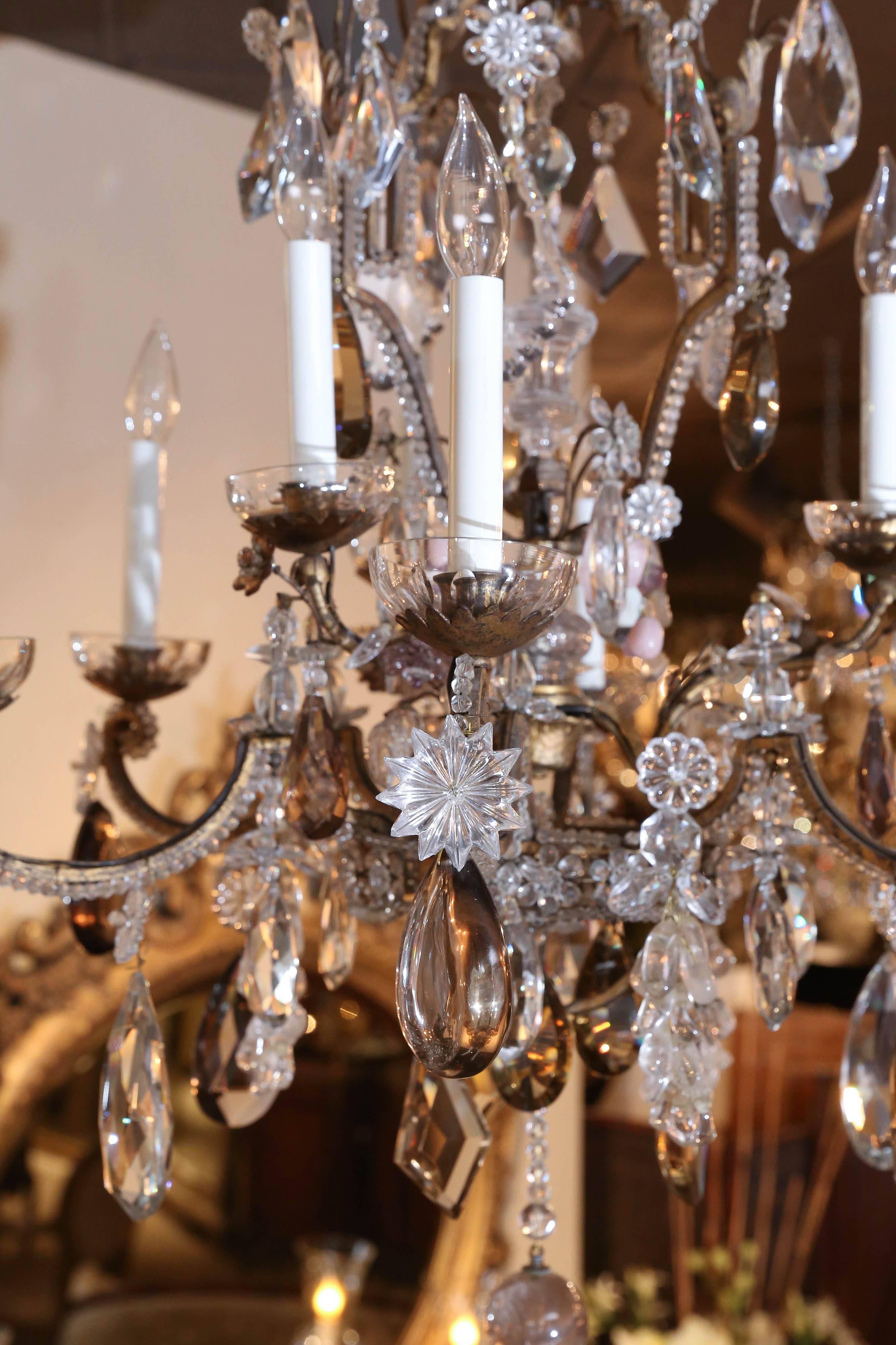 Fine bronze chandelier enhanced with small crystal beads that outline the
Bronze cage. Nine lights on two tiers light the fixture and it is in working
Condition. Large rock, purple and smoke colored crystal with clusters
of crystal grapes adorn