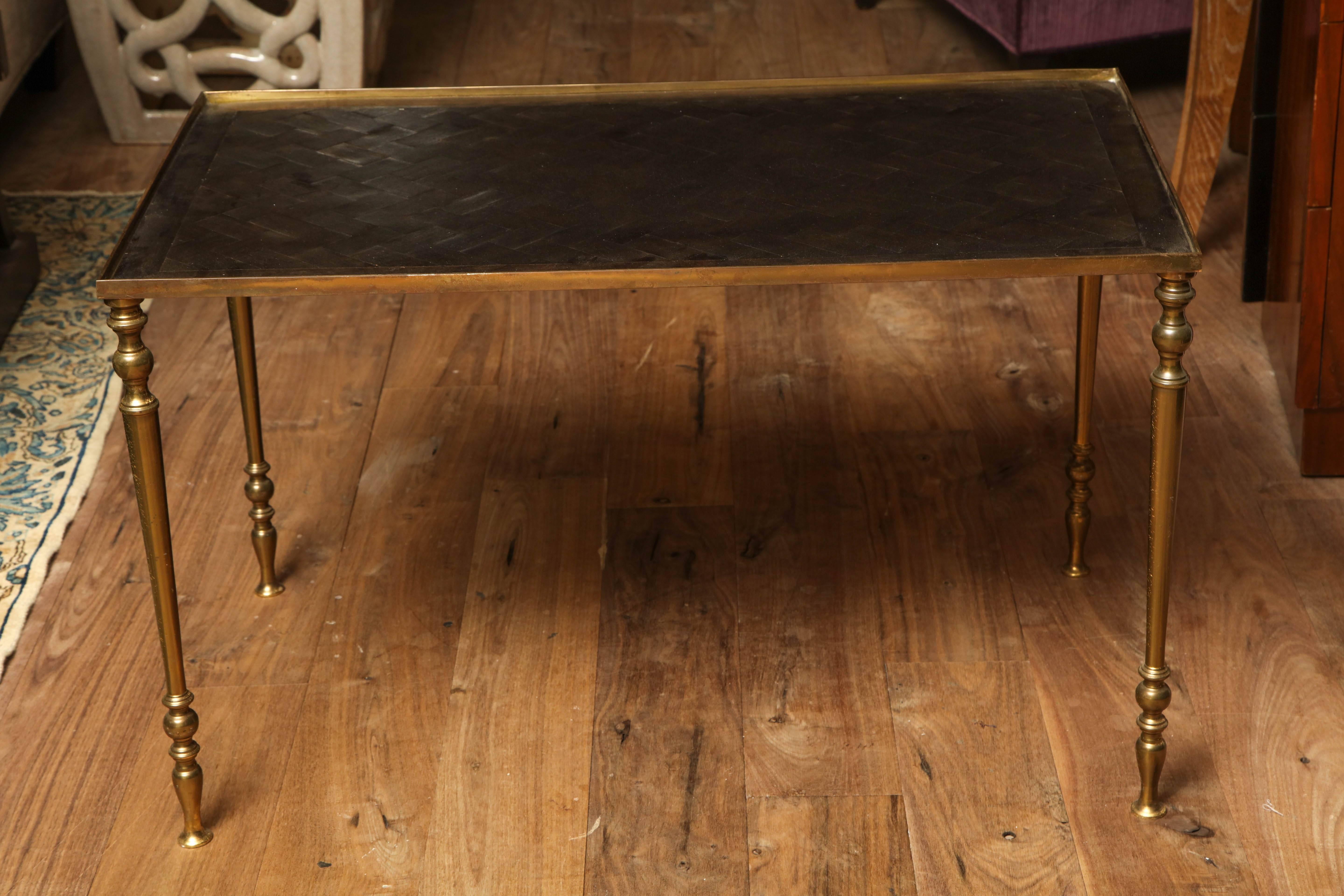Brass coffee table, France, circa 1940 with a replaced inset top of woven wood veneer under glass.