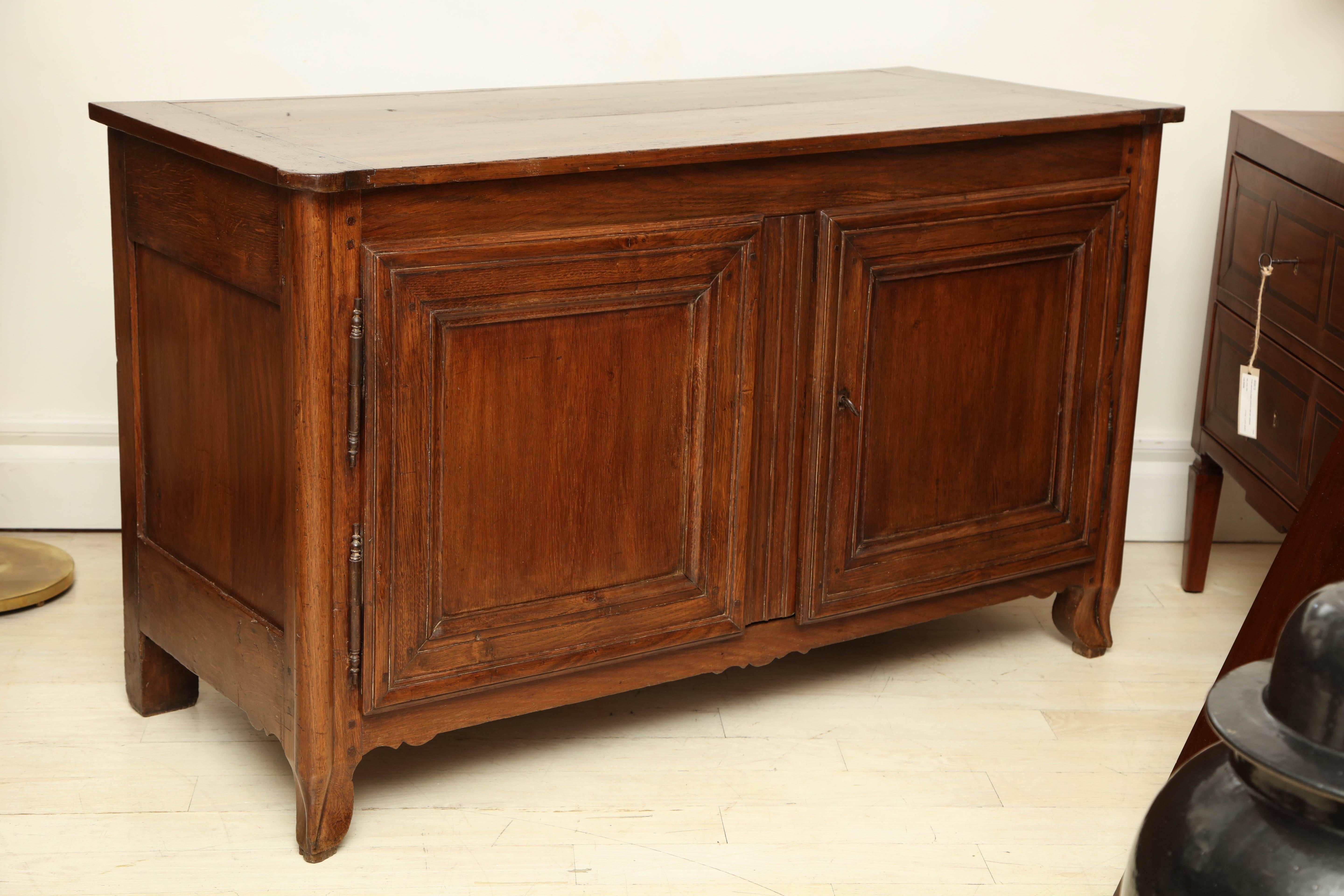 18th century French country oak sideboard with two paneled doors, curved side supports and interior shelf.