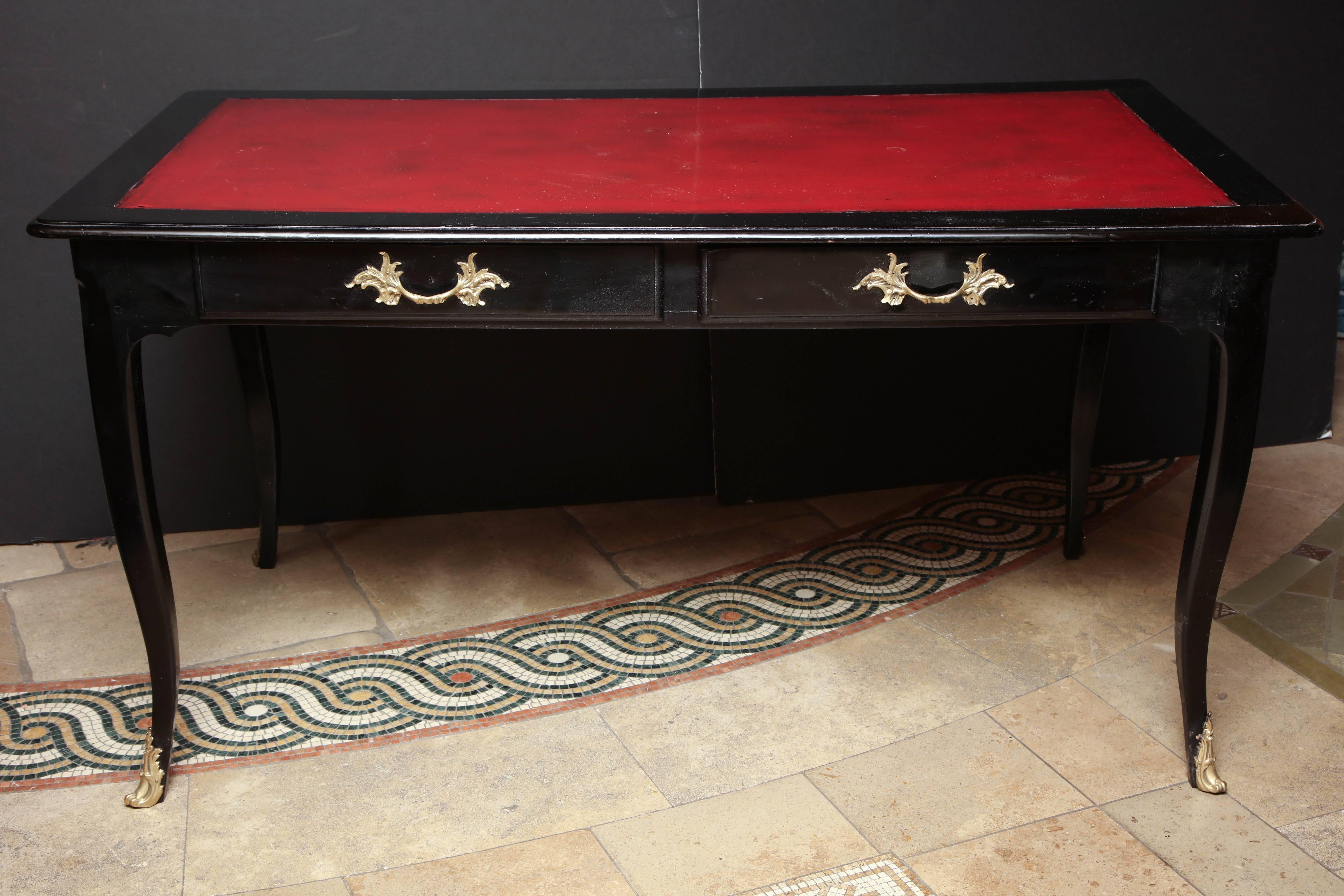 French Louis XV ebonized and lacquered red leather top bureau plat with bronze mounts and pulls with two frieze drawers.