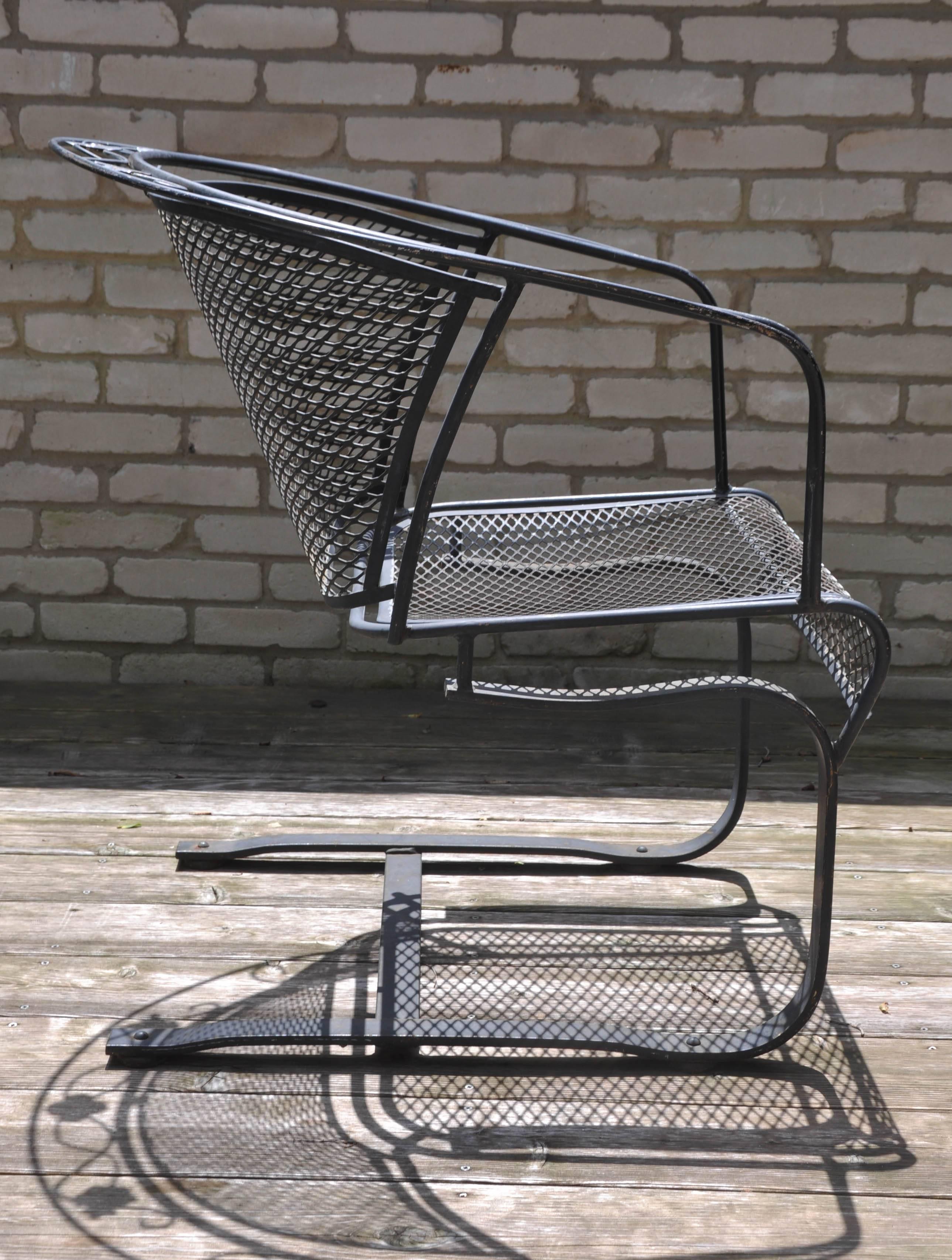 Set of four Mid-Century Woodard hand-formed wrought iron outdoor barrel back armchairs on a rocker base. Classic contoured diamond-mesh barrel back with hallmark 