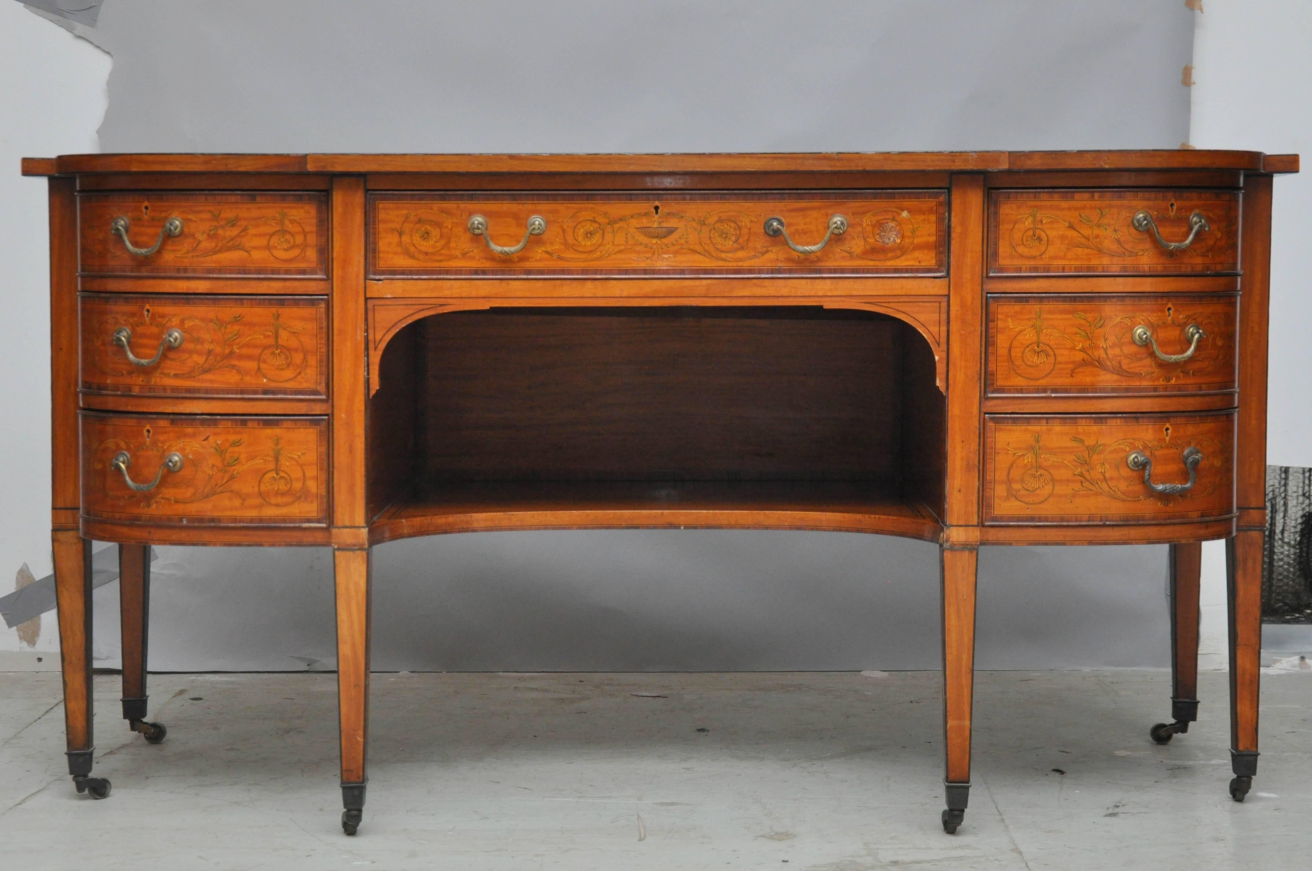 Edwardian period Sheraton revival inlaid satinwood desk with leather writing surface, signature Sheraton shapely rectangular surface design with left and right front rounded corners, below the writing surface are three graduating rounded drawers on