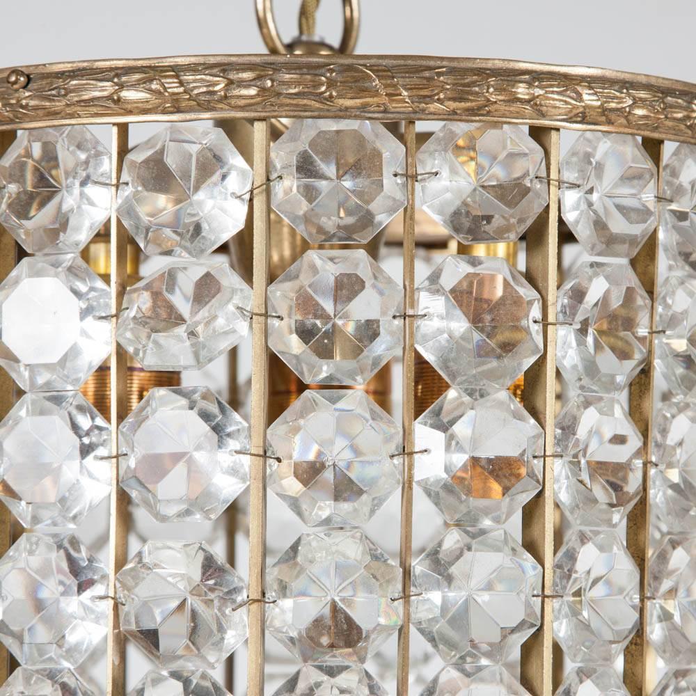 A gilt brass framed tubular crystal hanging light, with three internal light holders.
 