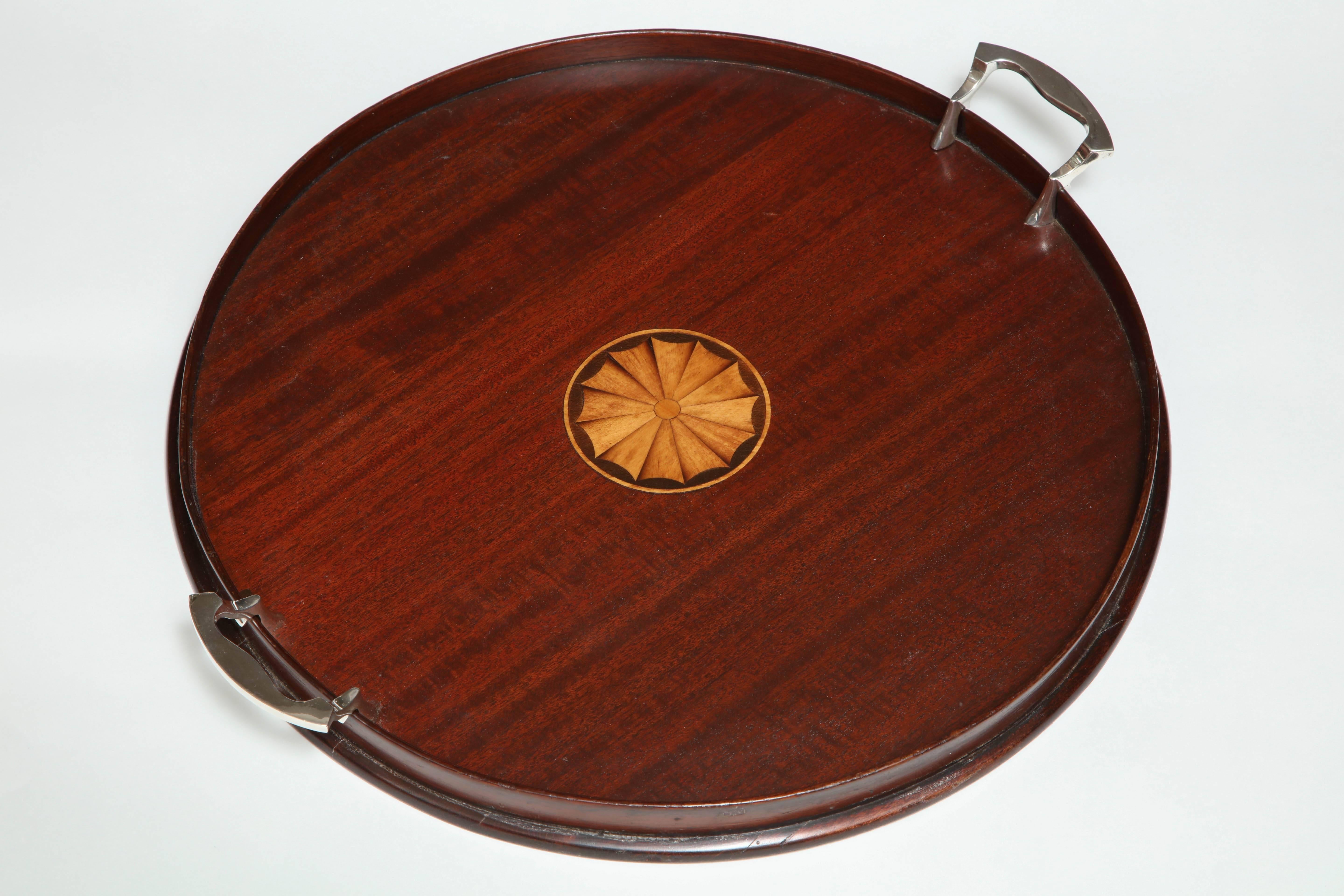 Edwardian, Sheraton-style, round wood serving tray with silver-plated handles, Manning, Bowman and Co., Meriden, CT., circa 1900. Measure: 16 1/8 inches in diameter x 18 1/2 inches wide (handle to handle) x 1 1/2 inches high. Lovely marquetry shell