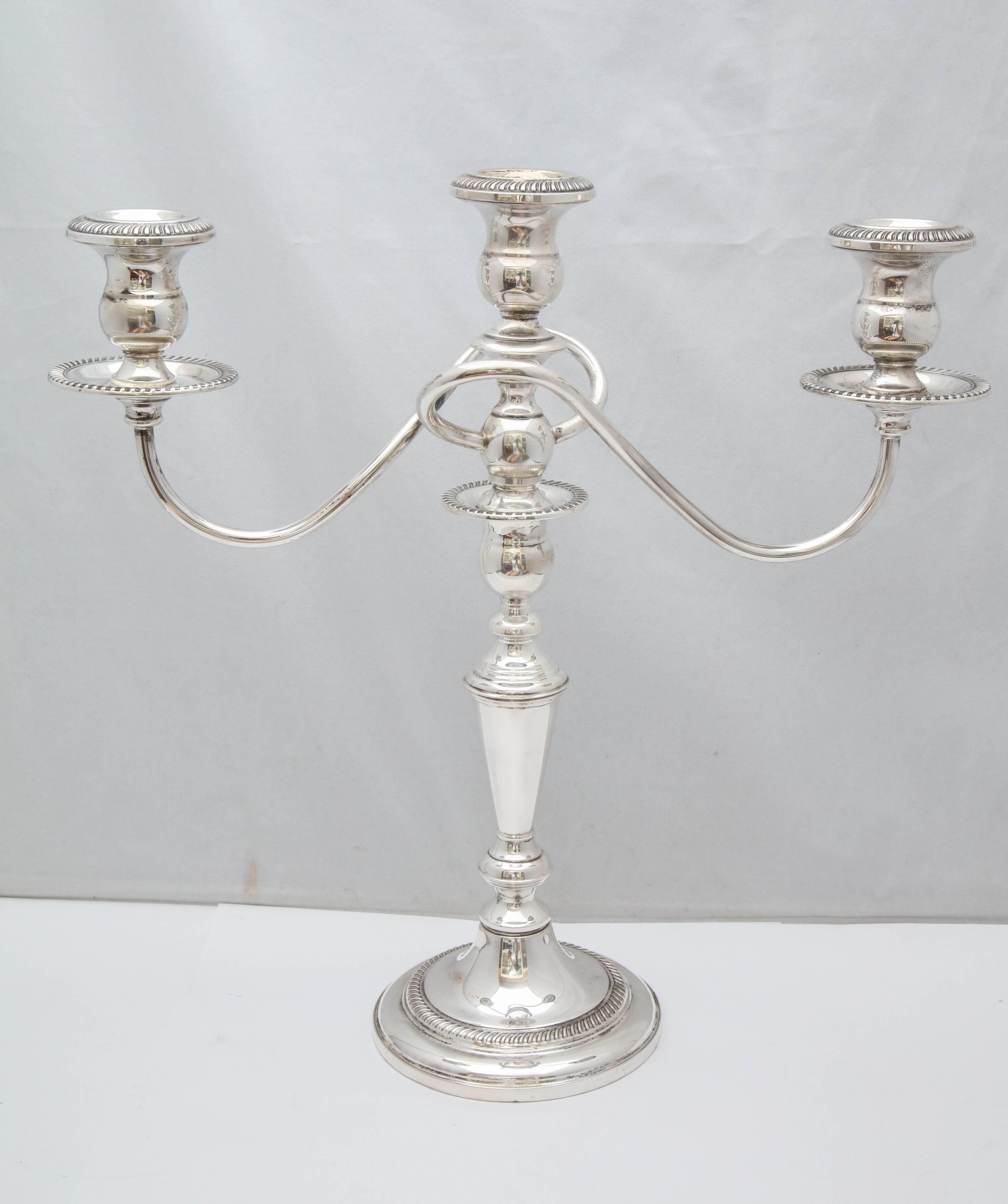 Pair of sterling silver, Empire-style candelabra that can convert to three different sizes, all of which fit the candelabra arms. Fisher Silversmiths, Inc., New jersey, circa 1930s. Measure: 13 1/4 inches high x 13 1/2 inches across arms x 4 1/2
