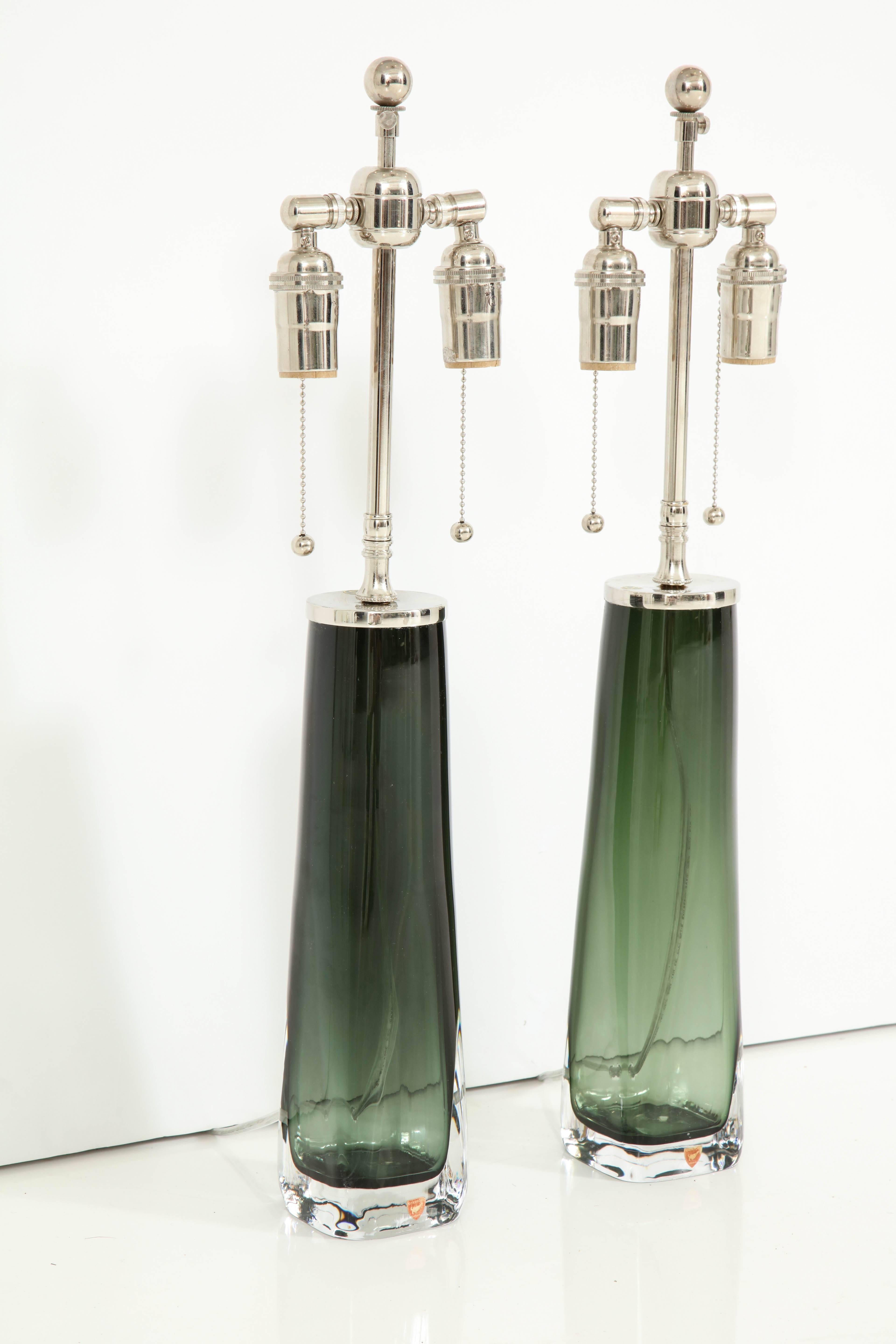 Stunning pair of forest green crystal lamps by Orrefors.
The lamps have been newly rewired for the US with adjustable nickel double clusters that take standard light bulbs.