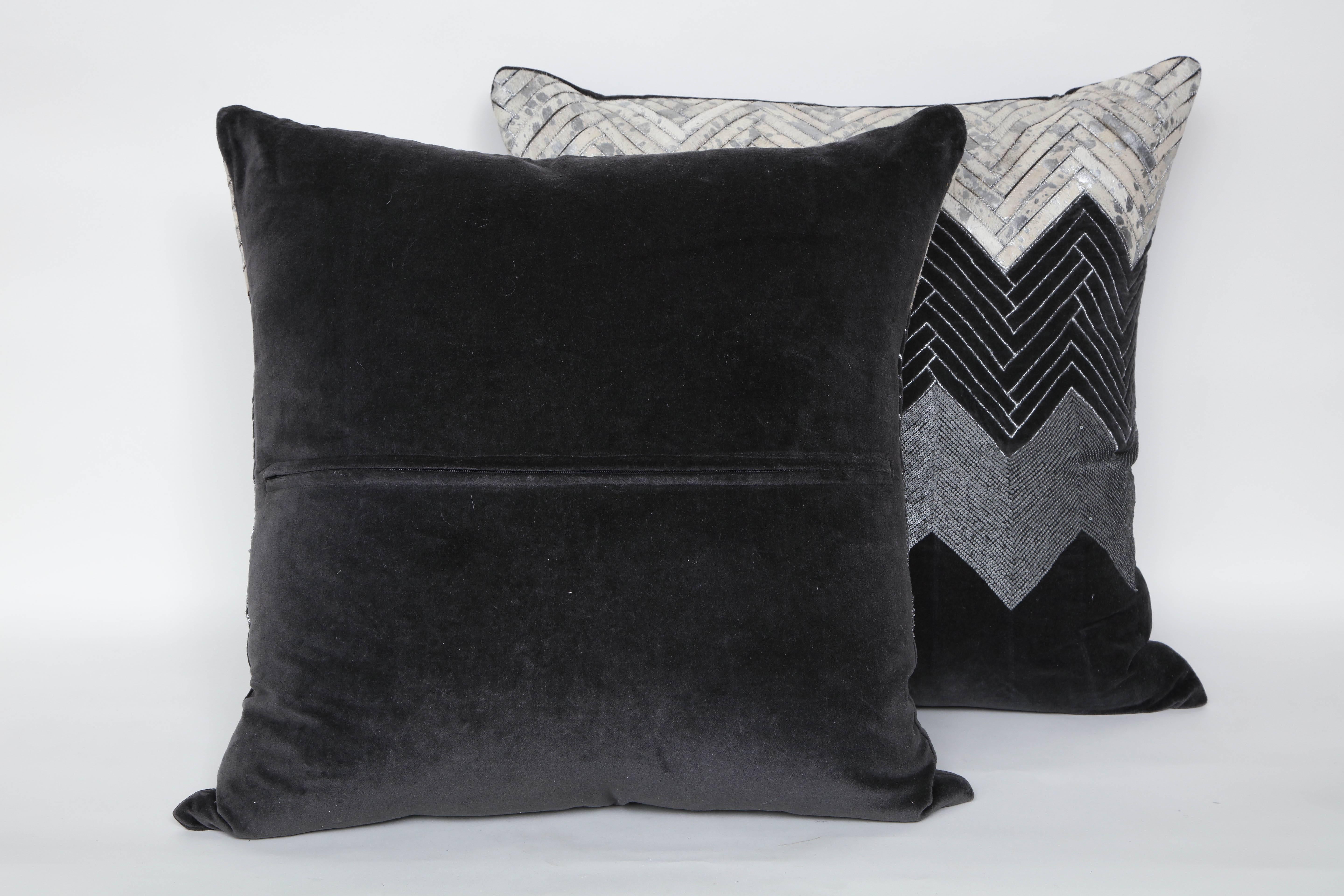 Pair of handmade pillows with bands of stitched white brindle hide, edge stitched velvet, and matte pewter mini sequins with grey velvet backs. Pillow inserts are feather and down, hidden zipper closure.