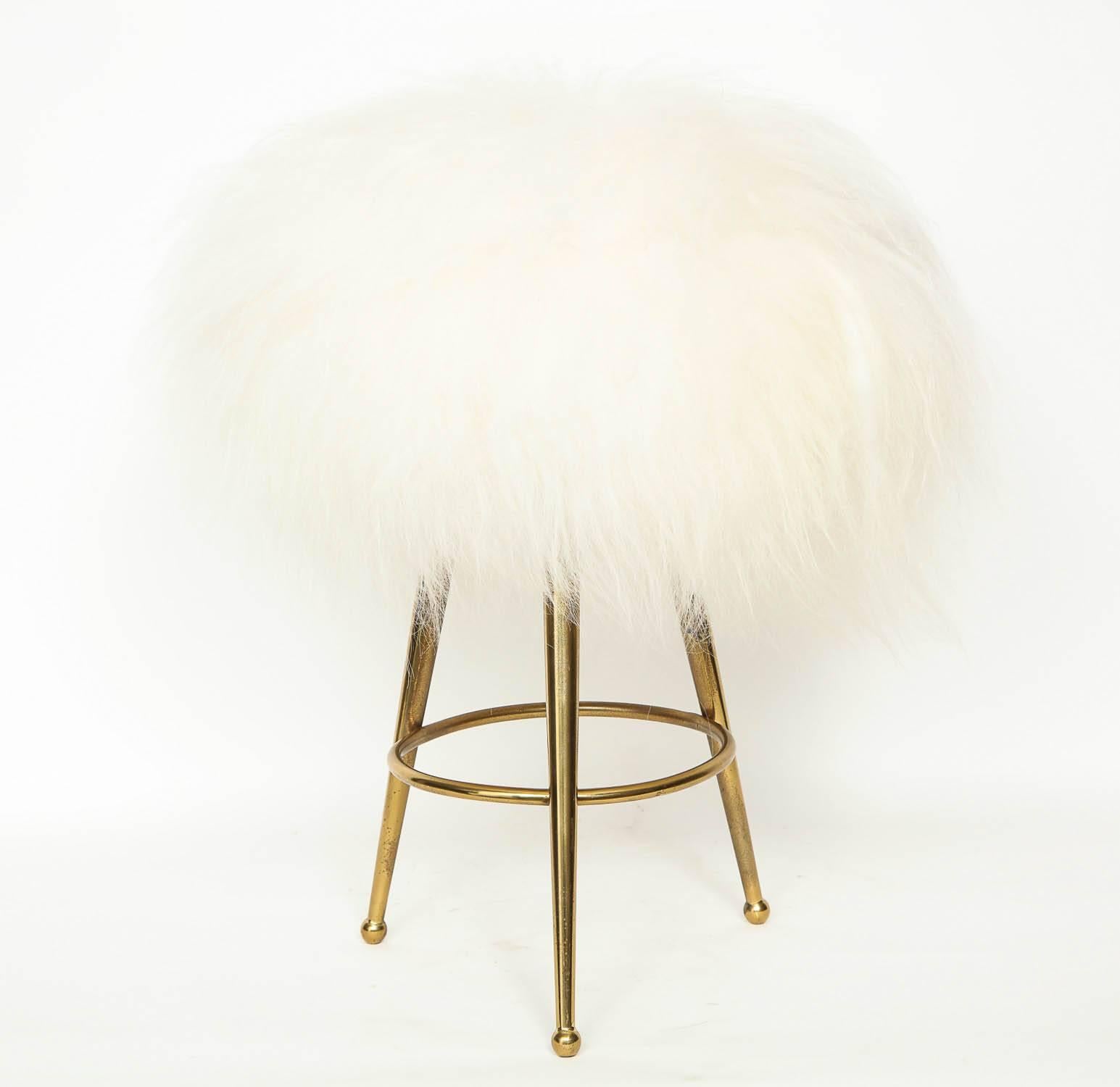 Pair of Mid-Century Italian stools with brass drumstick legs, upholstered in new white long haired Tibetan sheepskin.