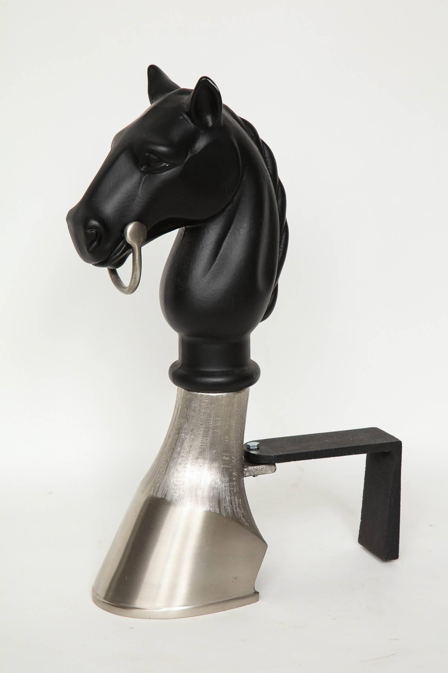 Striking pair of equestrian andirons with stylized black enamel heads resting on satin nickel hoof.