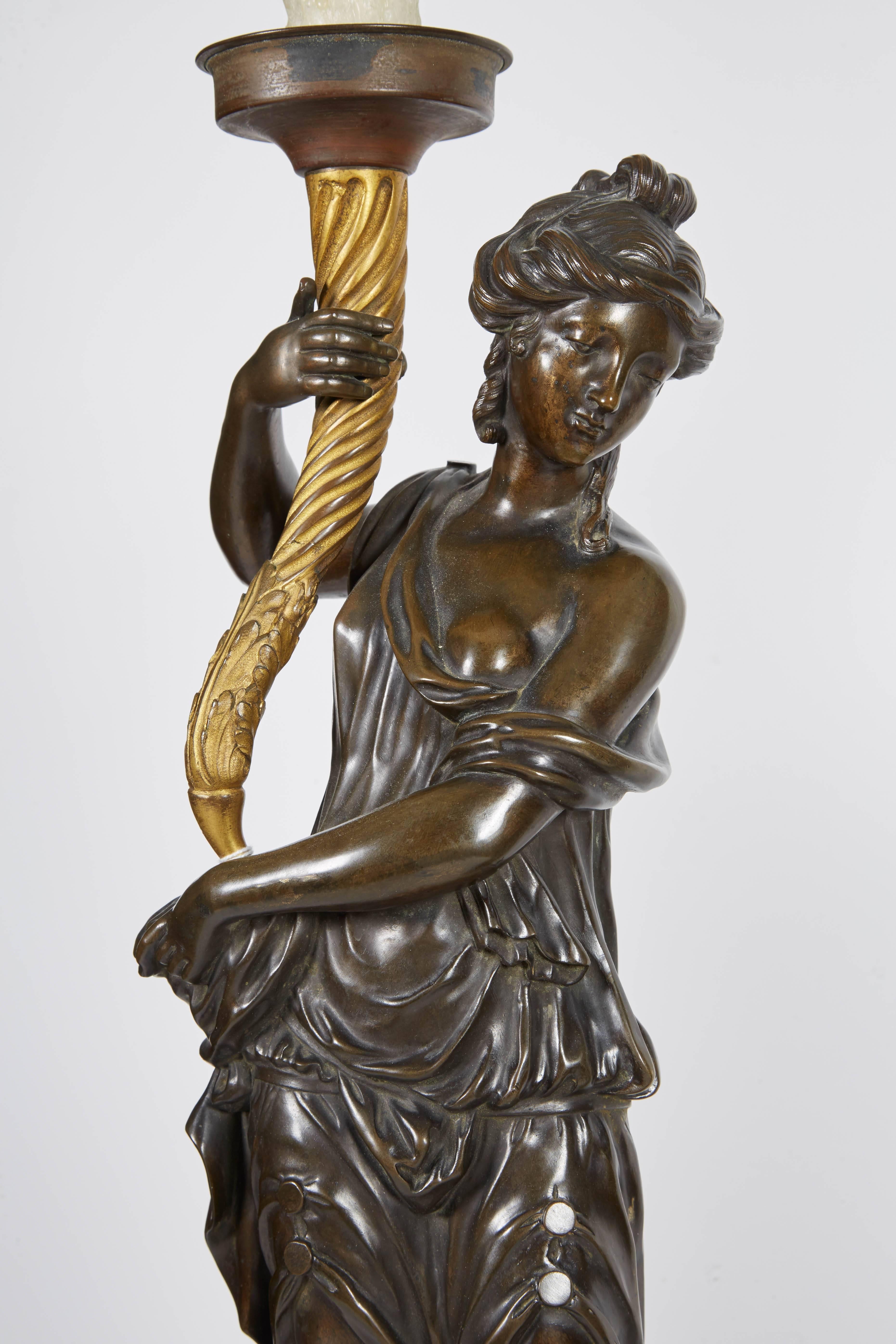 Large pair of French gilt and patinated bronze figural candelabra lamps,

French, circa 1820-1830. 

In the manner of Francois Remond, each modeled as a maiden holding a cornucopia above a cylindrical pedestal painted to show a continuous band