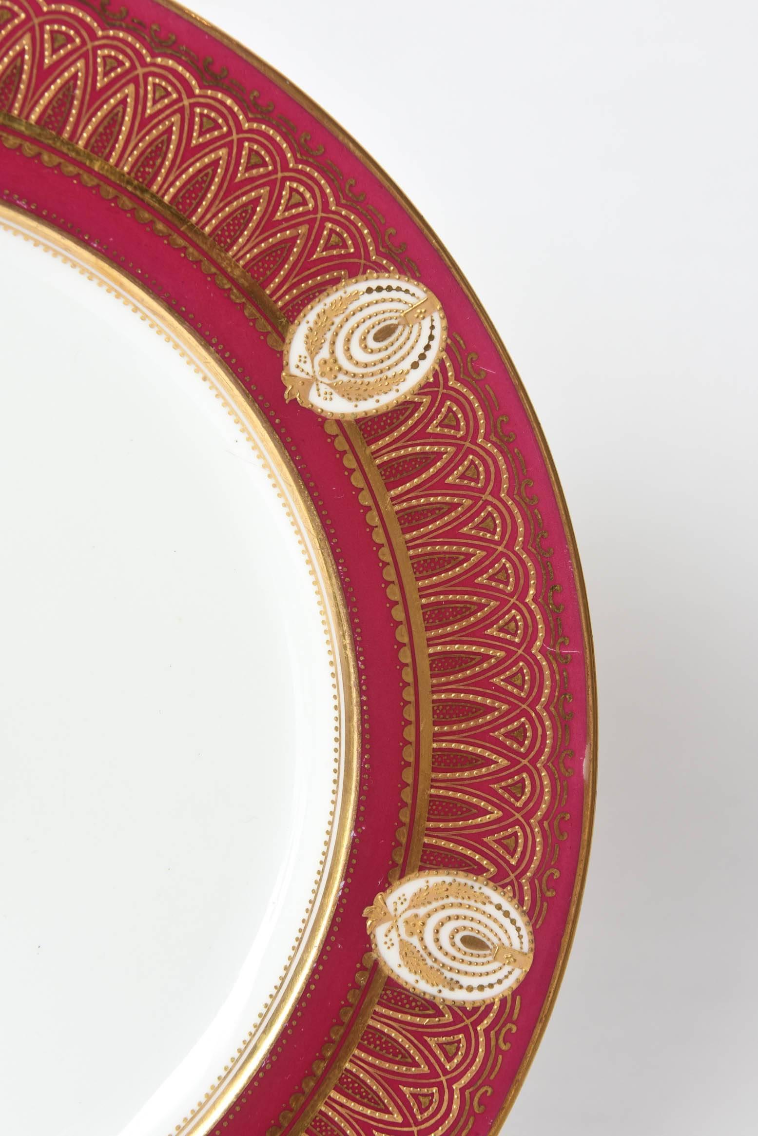 A gorgeous antique set of 11 dinner plates with really nice detail to the design on the collar of the plate featuring oval cartouches of raised tooled gilding on a ruby ground. We love the center medallion and the seven carouche surround on the