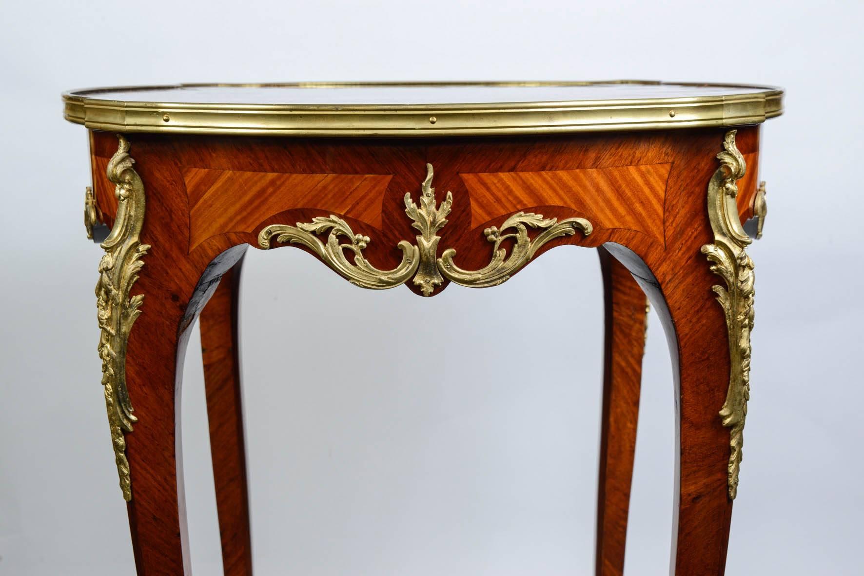 Round Gueridon in the Louis XV style, marquetry if diverse precious wood, decorated with gilded bronzes.