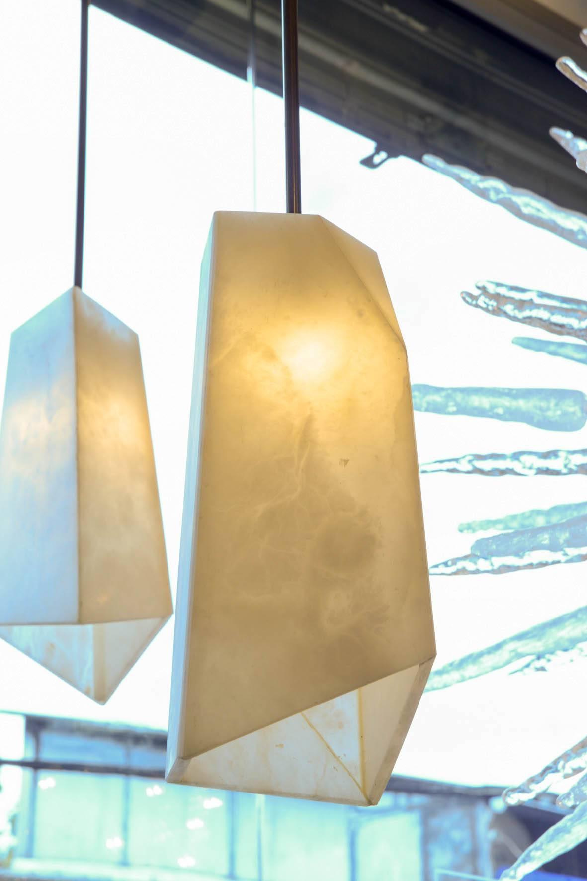 New design by Glustin Luminaires, asymmetrical suspensions made of different plates of alabaster put together hold by a brass stem.