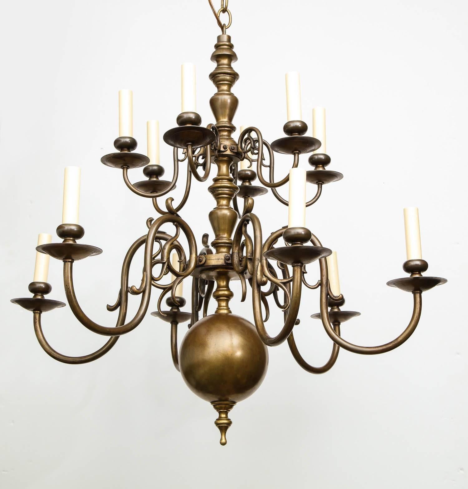Fine turn of the century brass chandelier having two tiers of lights, both having six scrolled arms, the center shaft with balustrade turnings and ball finial, the whole with good bronze like surface and recently re-electrified.
