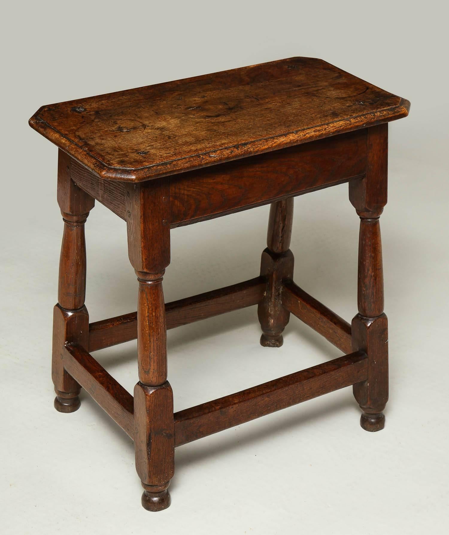 Very good late 17th century English oak joined table, the thumb molded top with canted corners, over molded apron and standing on splayed balustrade turned legs joined by box stretcher and standing on original turned button feet, possessing great