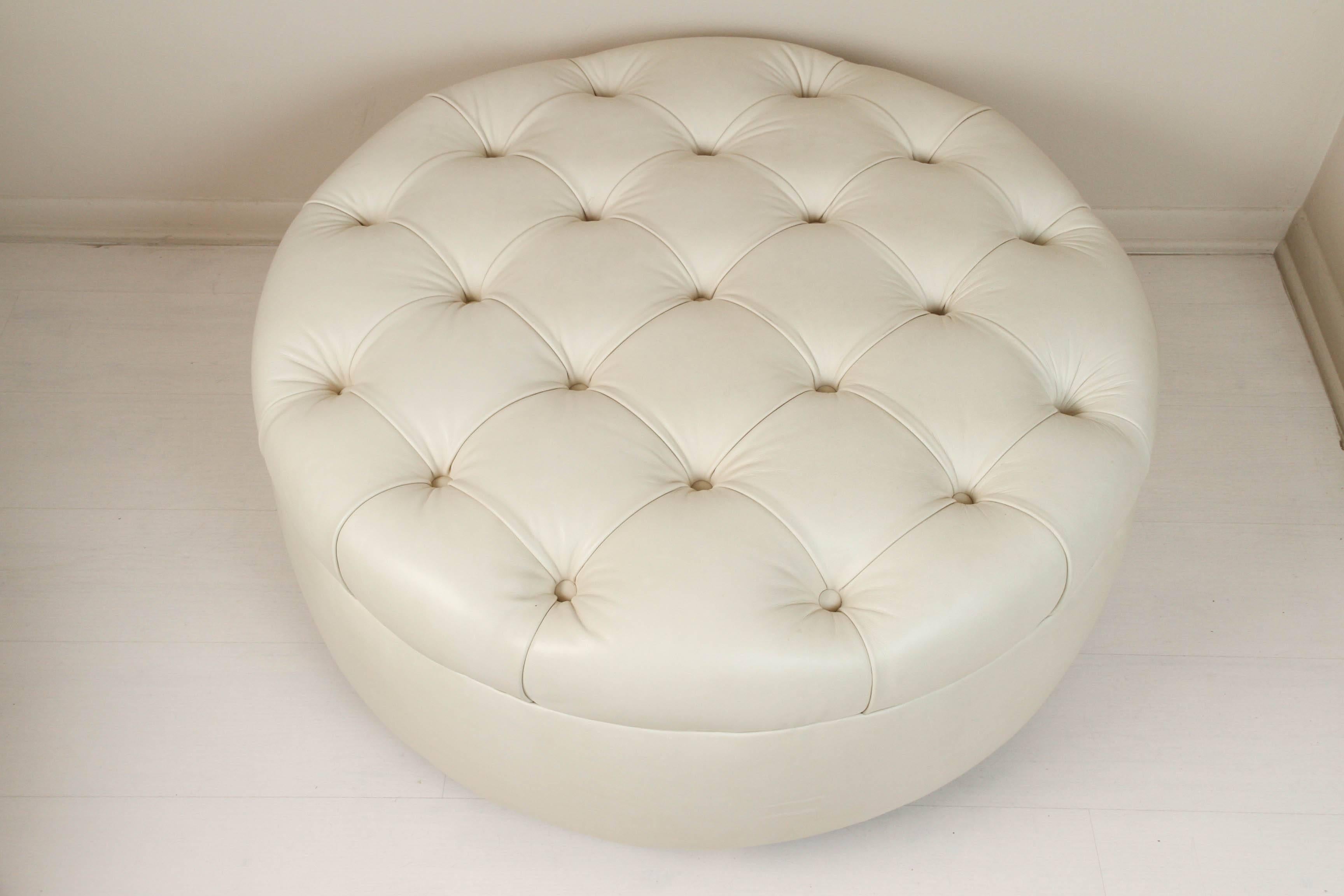 Creamy light beige leather ottoman with tufted top. French, 1960s and on brass wheels. Is a perfect substitute for a coffee table.
 