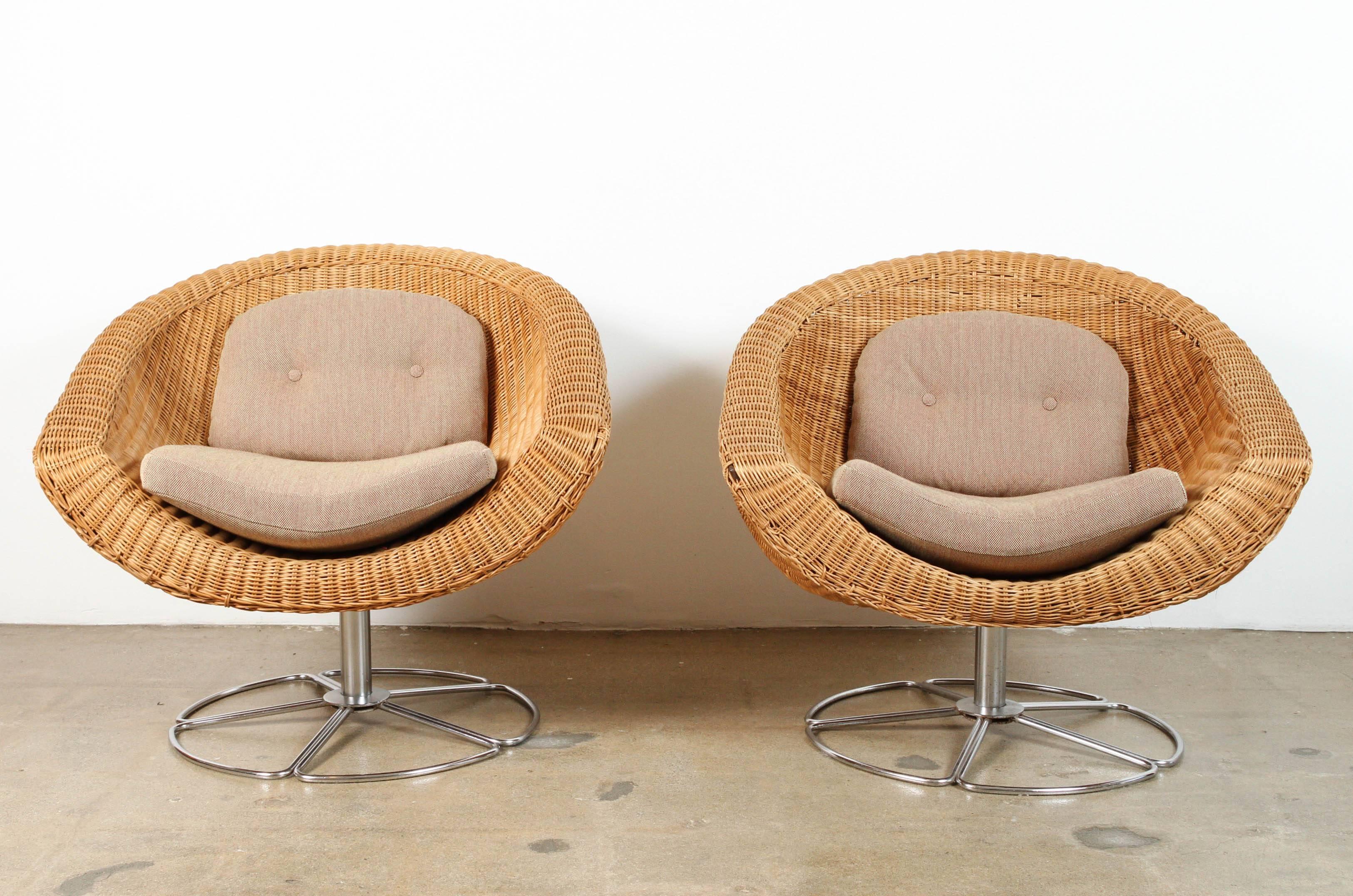 Pair of 1960s, vintage Wicker swivel chairs. Cushions in a sturdy cotton beige with deep orange/red highlights. Very unique and quite comfortable. One of a kind!