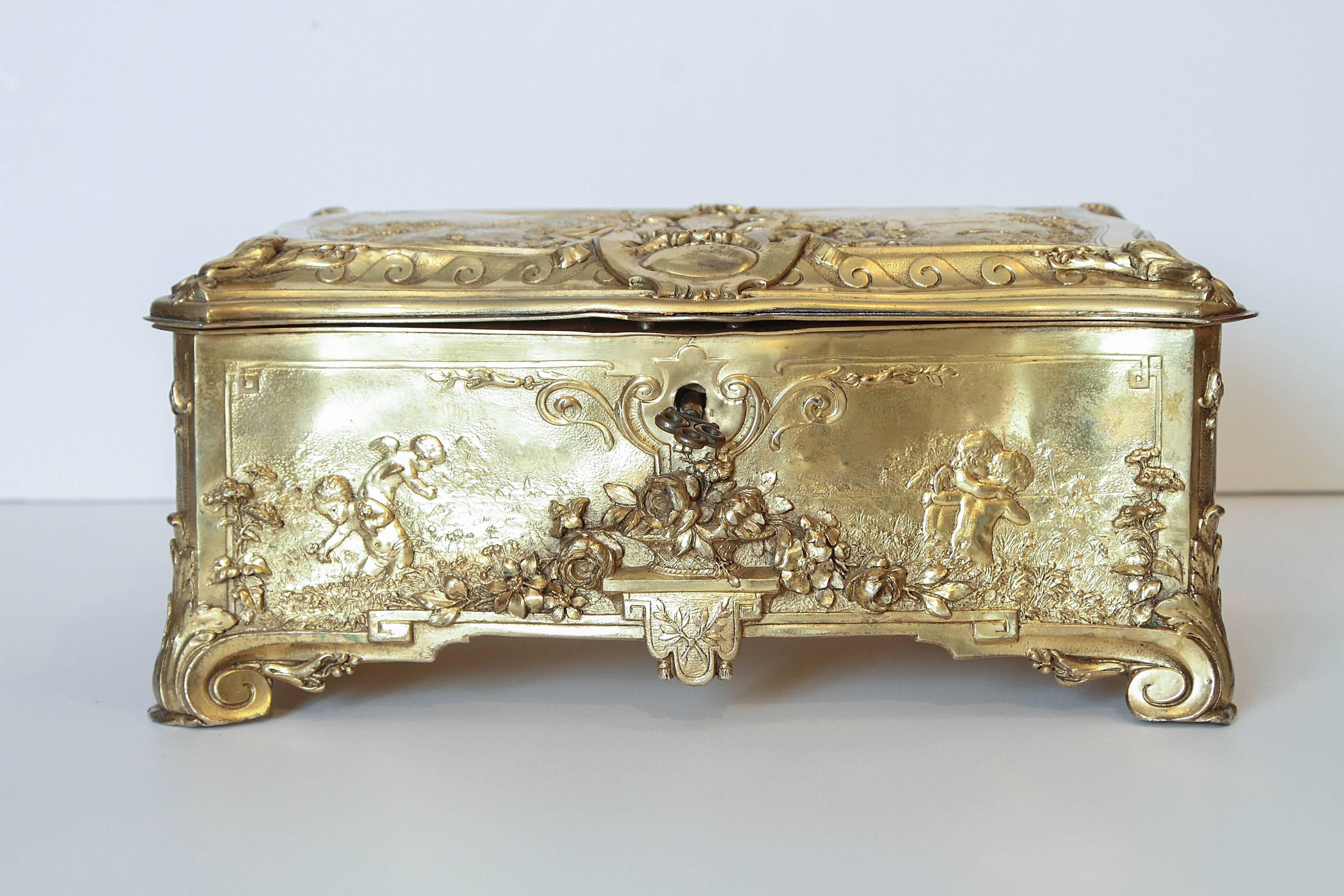 Finest quality French 19th century bronze doré box. Beautiful scenes of cherubs at play on all sides. Boucher scenes. Lined with a beautiful silk original key.