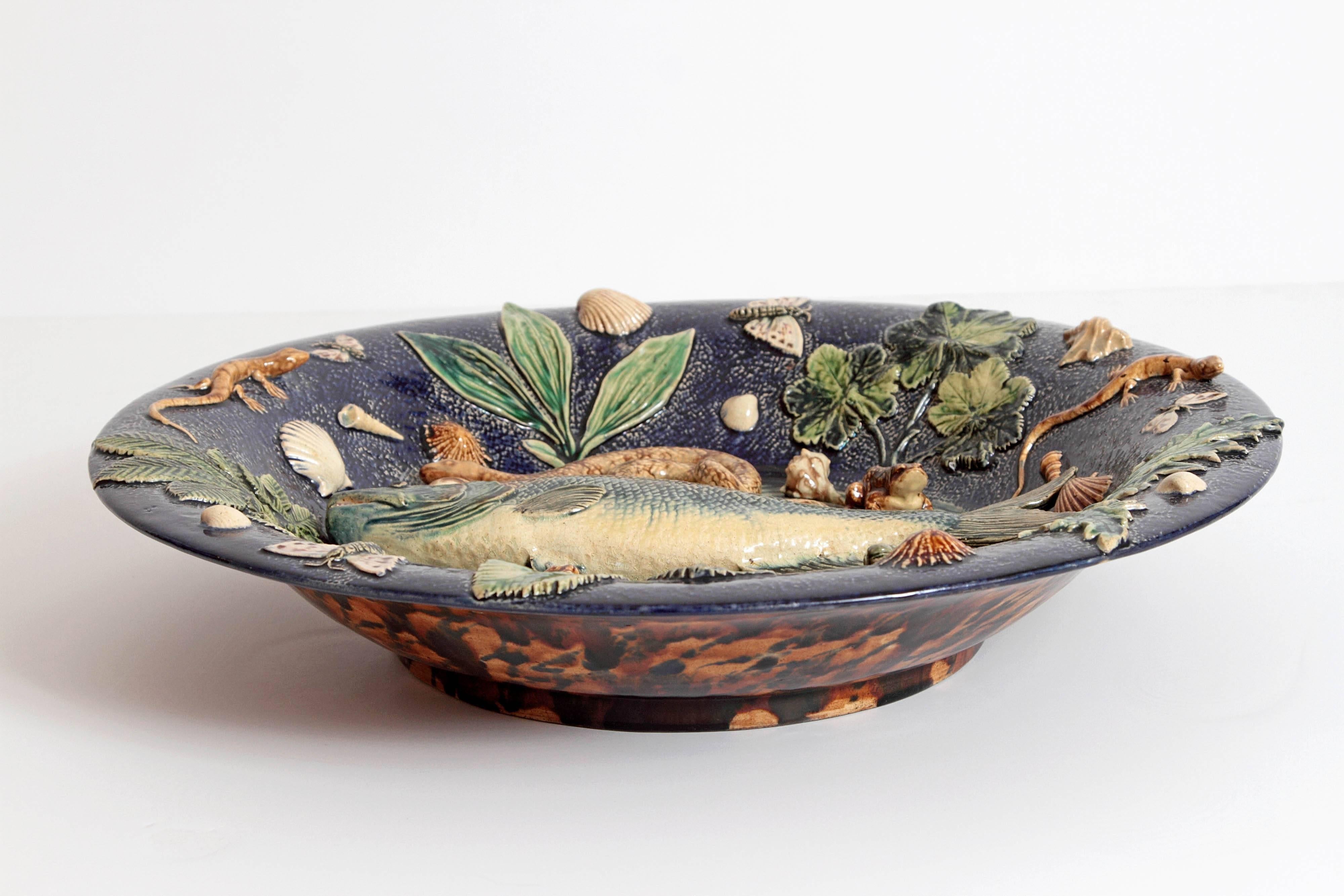 Large Palissy charger composed of a central trout, snakes, frogs, moths, shells and leaves on a cobalt ground, signed by Victor Barbizet.
France, circa 1875.
 
May be displayed on a table, a stand, or hung on a wall.