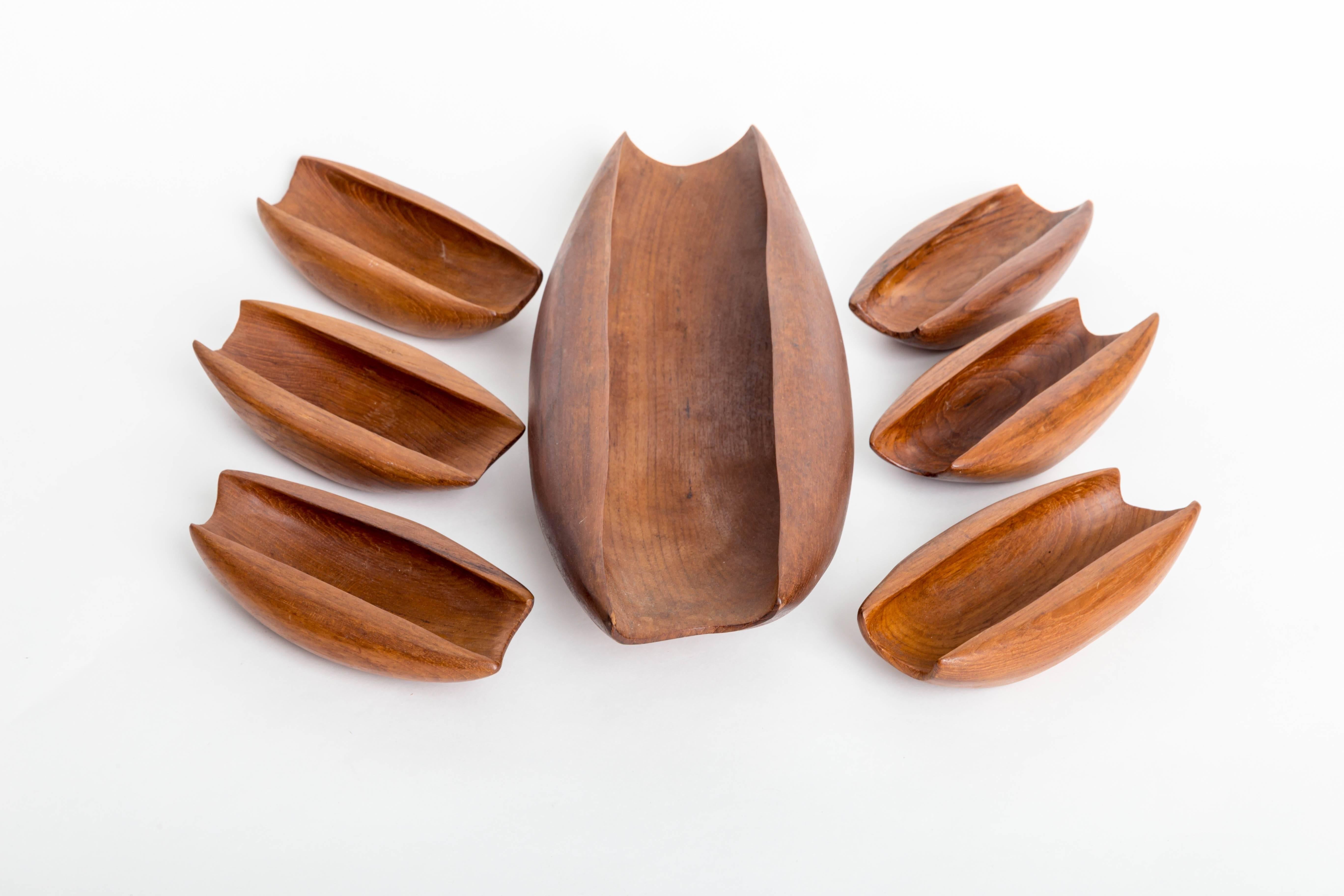 Seven piece solid teak vessels carved from single pieces of wood
One large vessel with six smaller vessels.