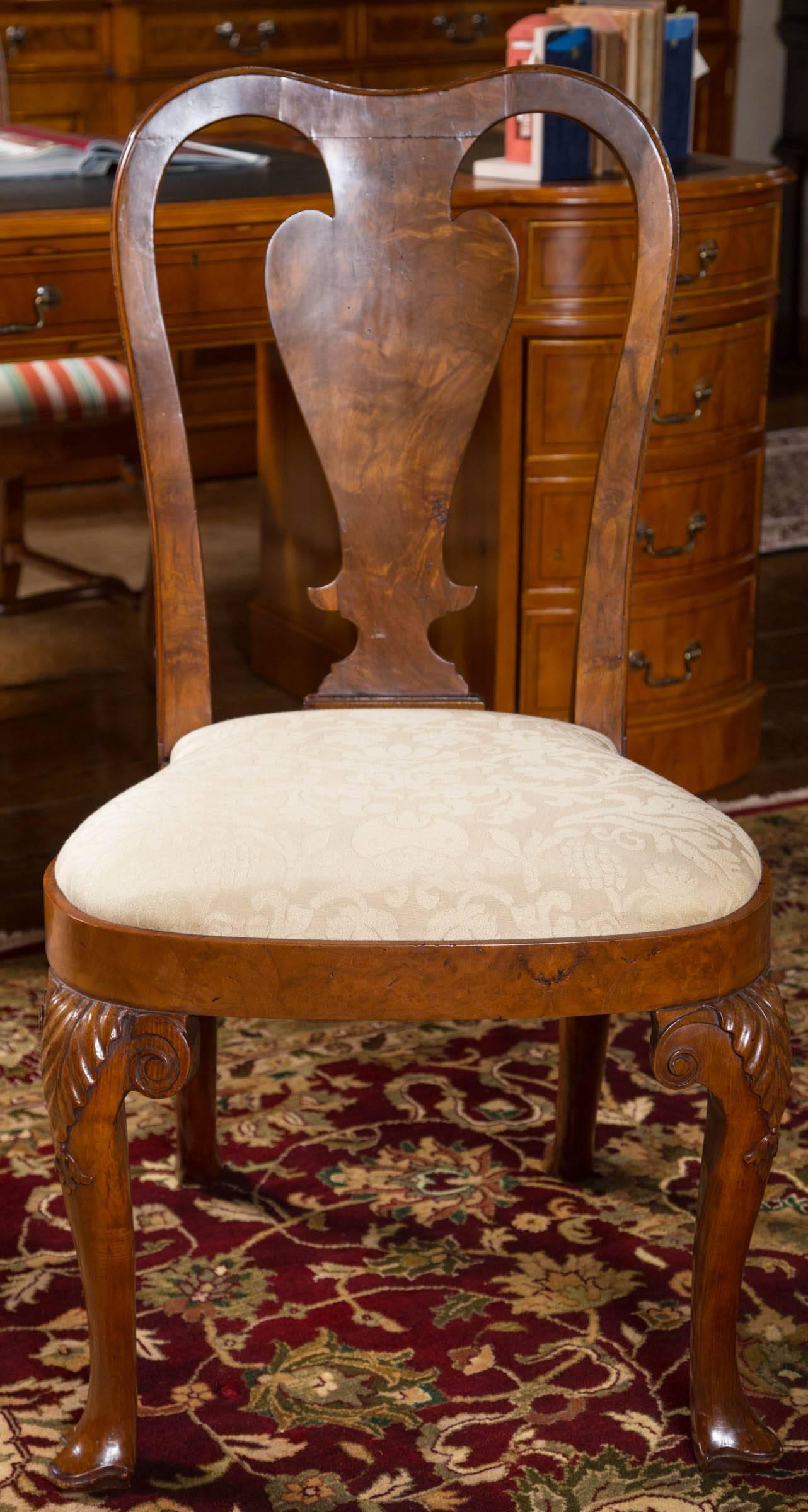 Rare set of six George II dining chairs in figured walnut. Following the classic Queen Anne style, these are clearly Georgian chairs with the shorter backs and flat uprights and splat while the legs are minus the stretchers often associated with the