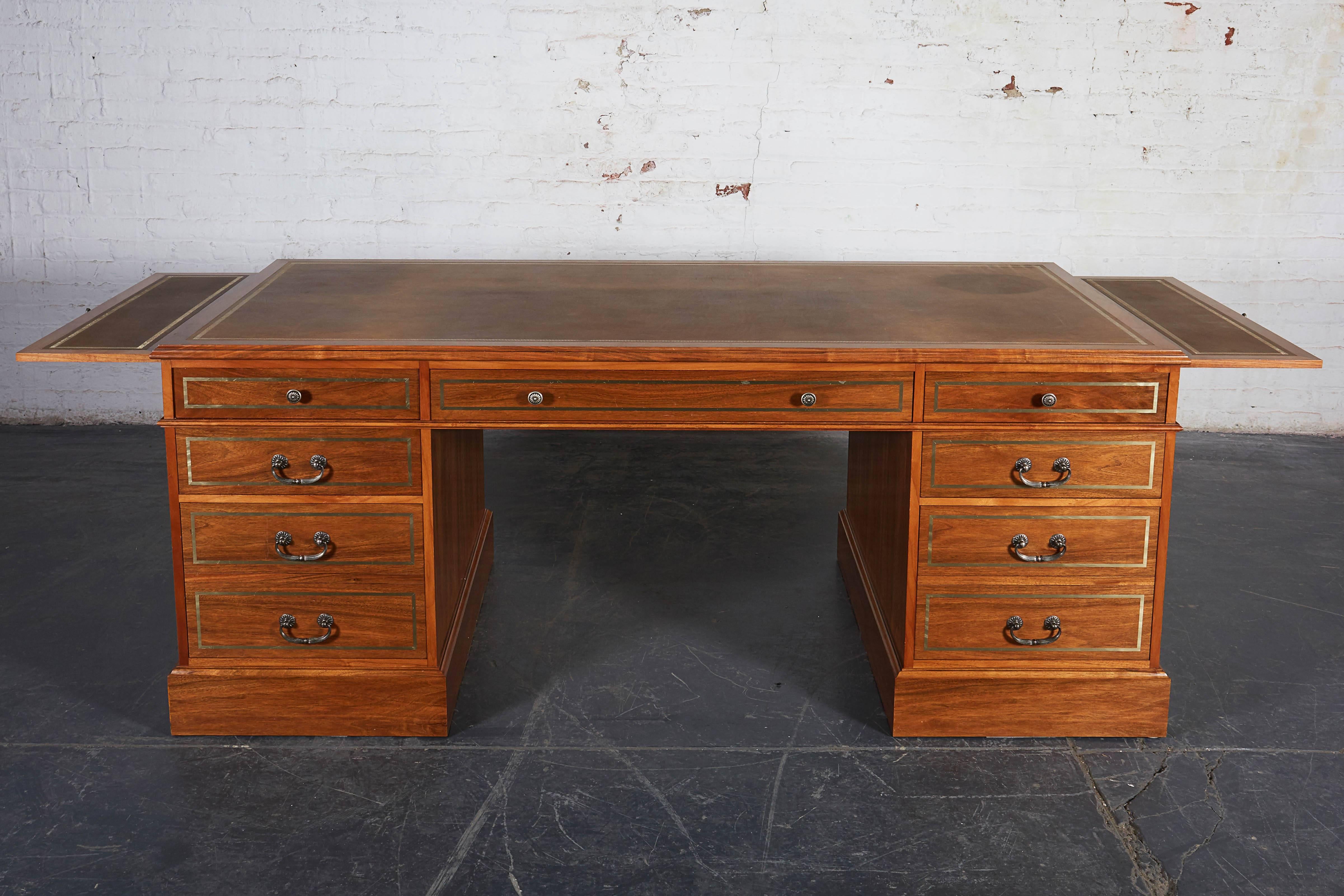 Bench made in England by Charles Manners of Manners & Co. With tooled leather top; inset with nickel banding throughout and featuring custom nickel hardware by P.E. Guerin. One side fitted with drawers including two file-hanging drawers and the