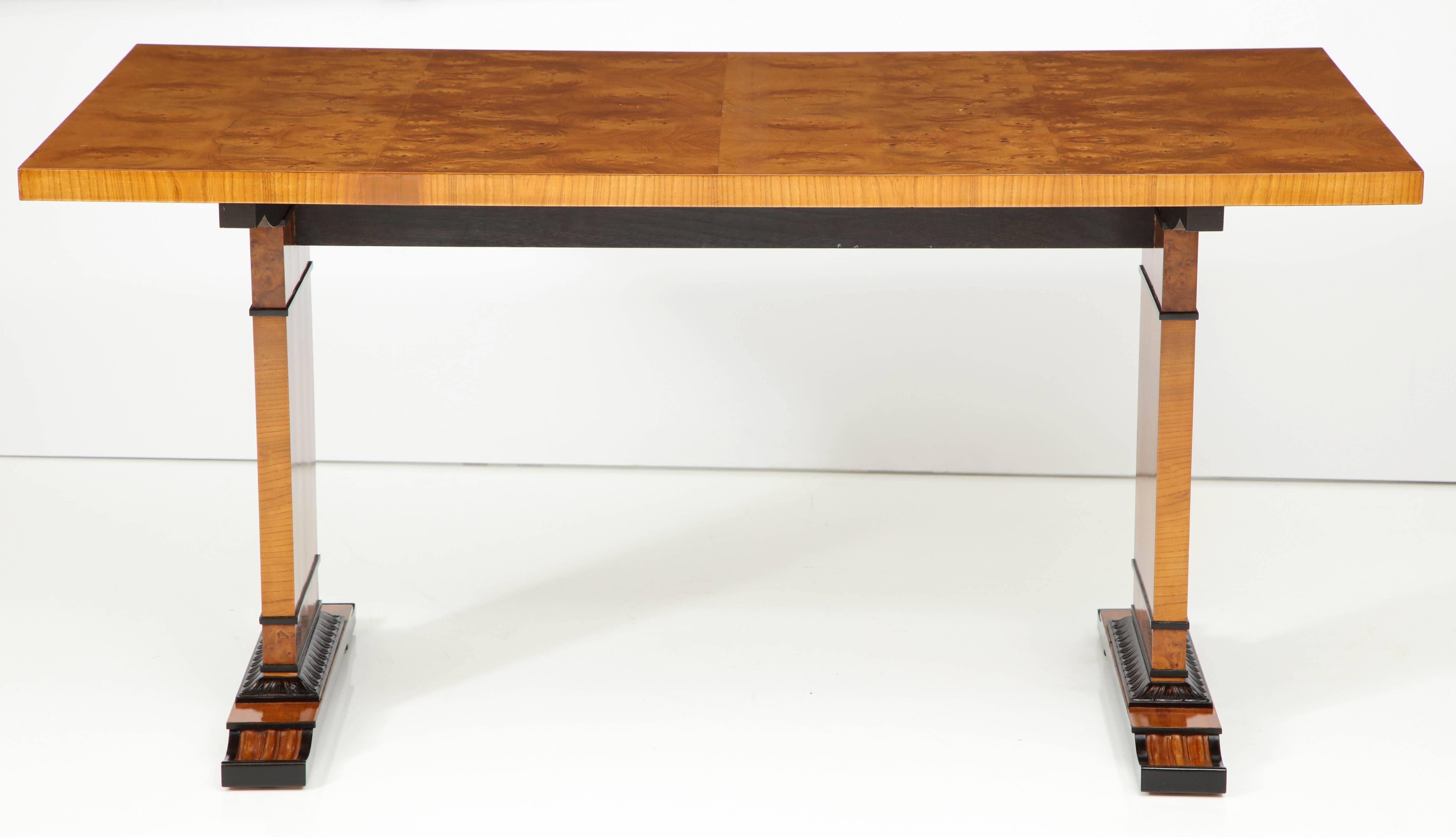 A Swedish Grace, burl elm, elm and ebonized table or desk, circa 1940 by Erik Chambert, with a rectangular top raised on rectangular supports and leaf-tip carvings.
 