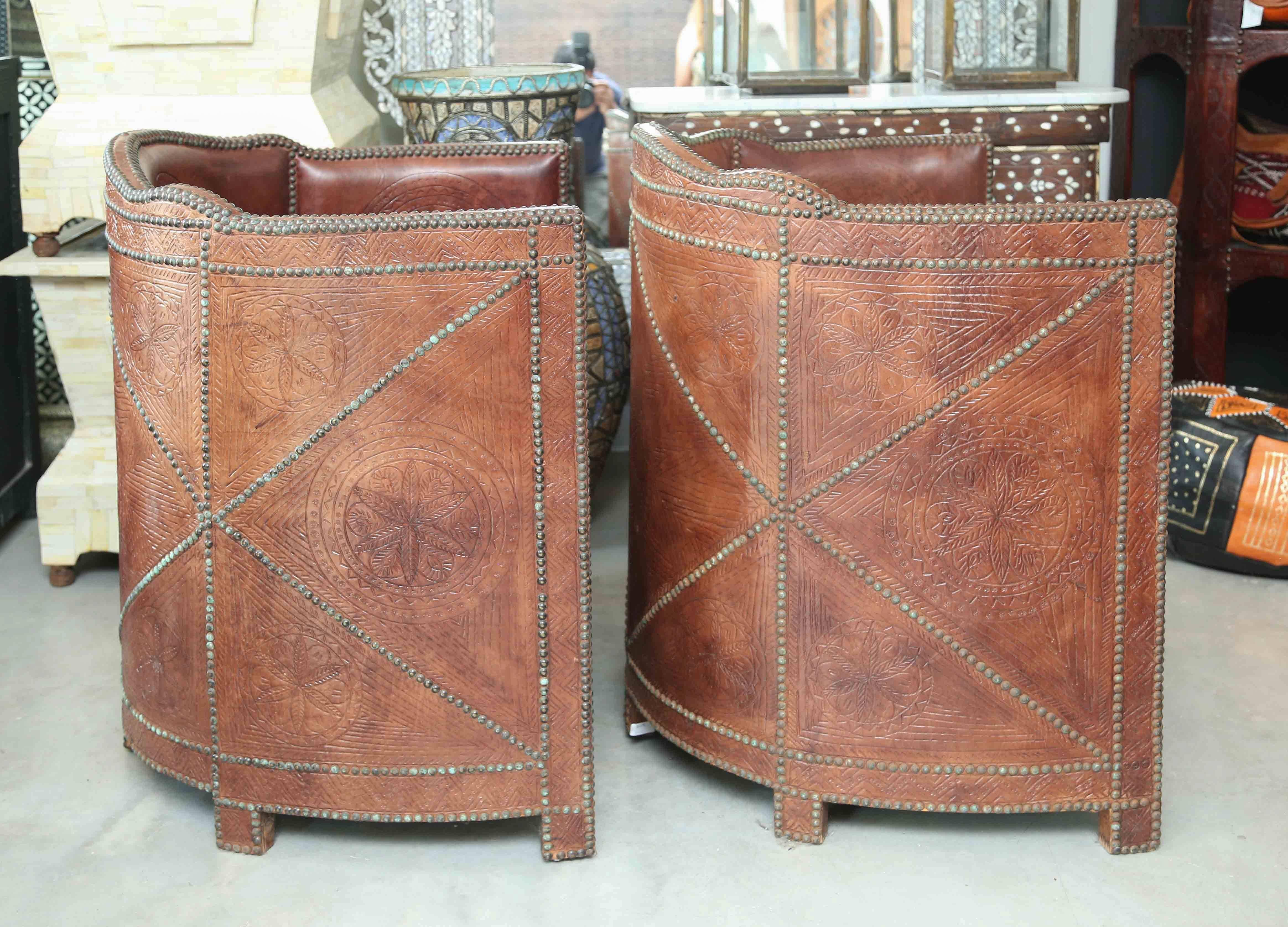 Made with hand tanned hand tooled leather in Morocco, showing the natural imperfections in the leather. These chairs are vintage, circa 1960s as evidenced by the wear and tarnishing on the brass nailheads. Beautifully handcrafted and decorated,