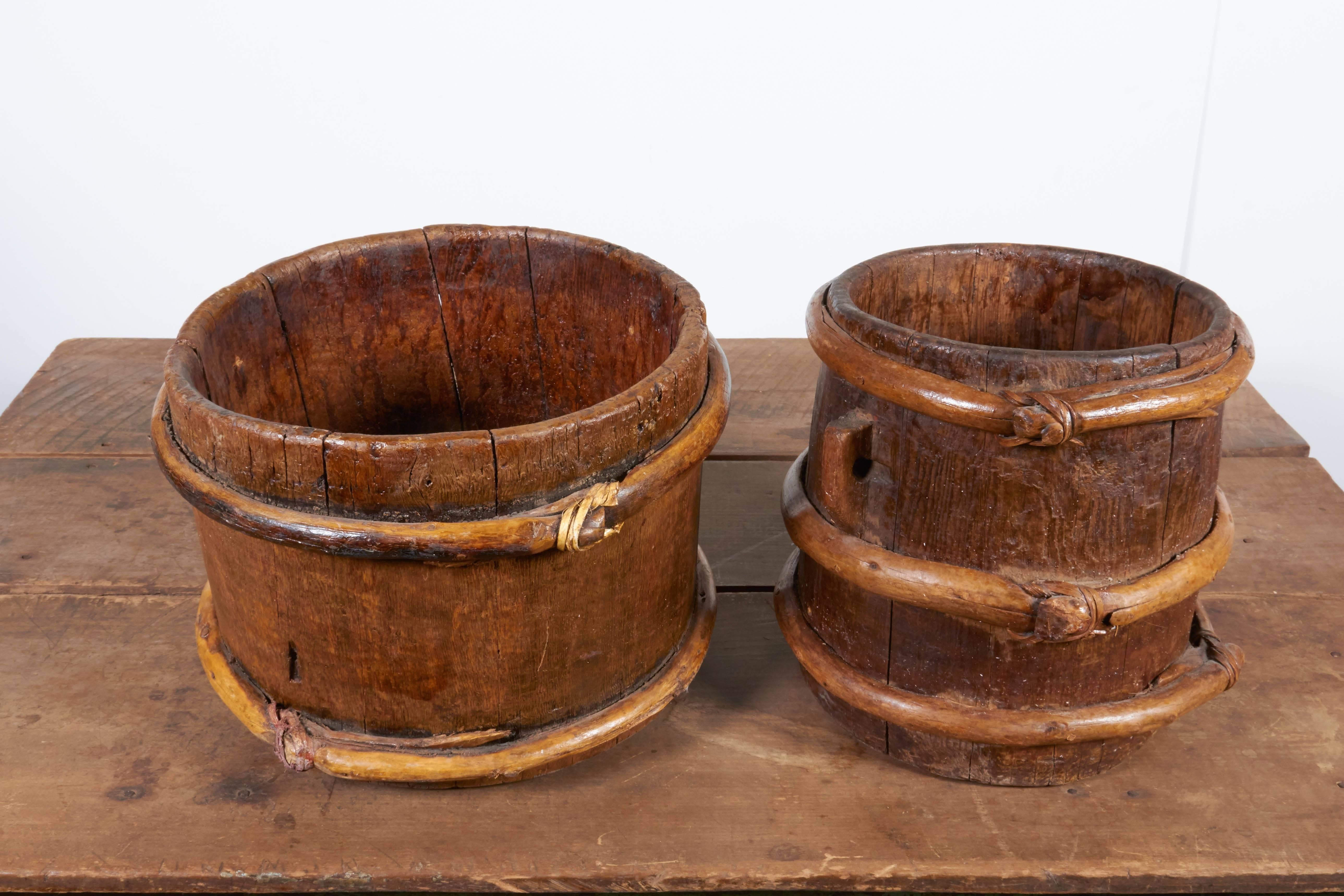 Two early 20th century Tibetan yak butter churns with terrific patina, carved handles and knotted decoration. Very useful and attractive in many settings. Priced individually. 
Dimensions: Left in main image: Diameter 14, height 10.5 Right: Diameter