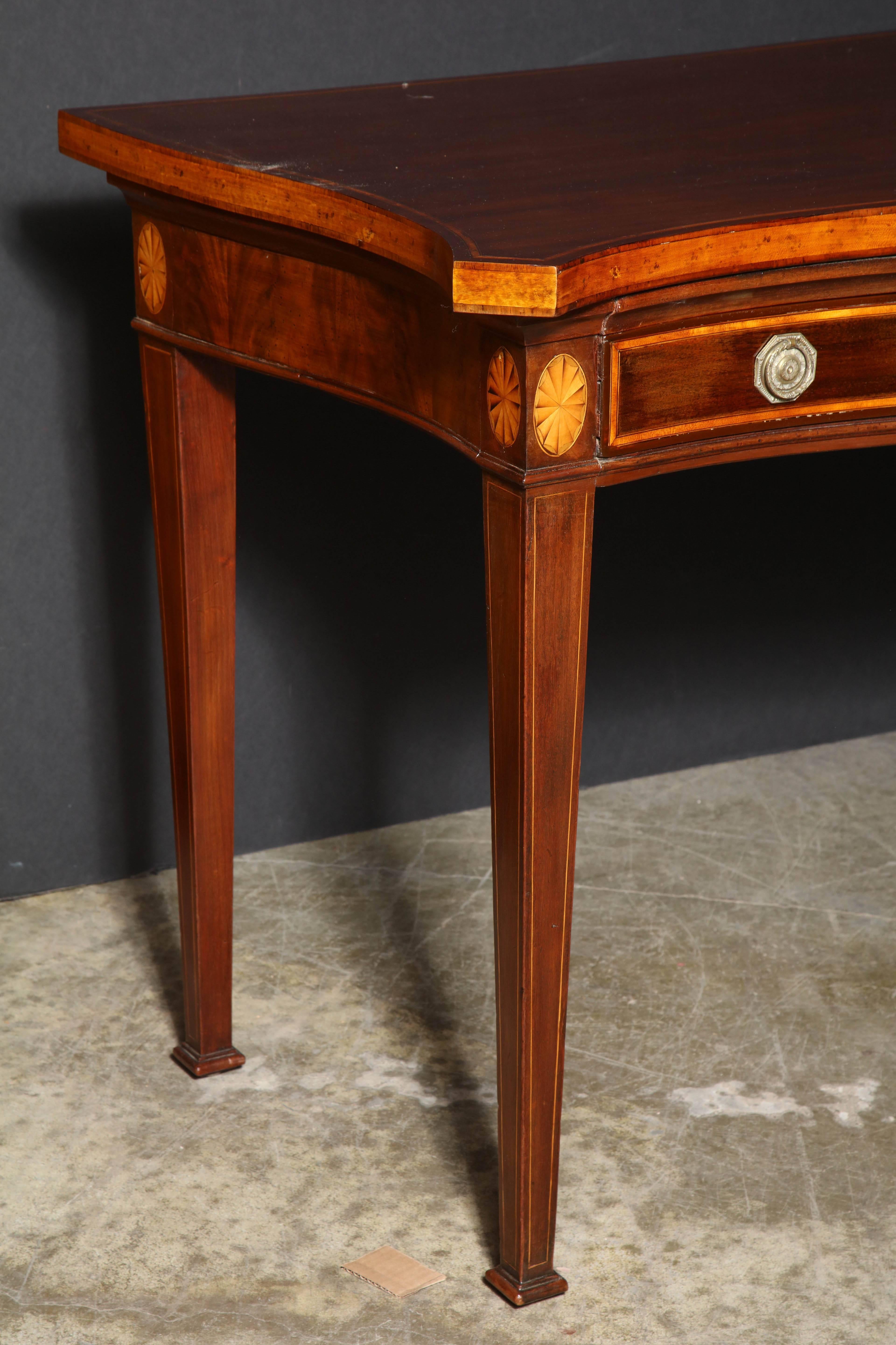 George III mahogany inlaid (oval and fans) serpentine console table with two apron drawers, satinwood banding and tapered legs, with original pulls.