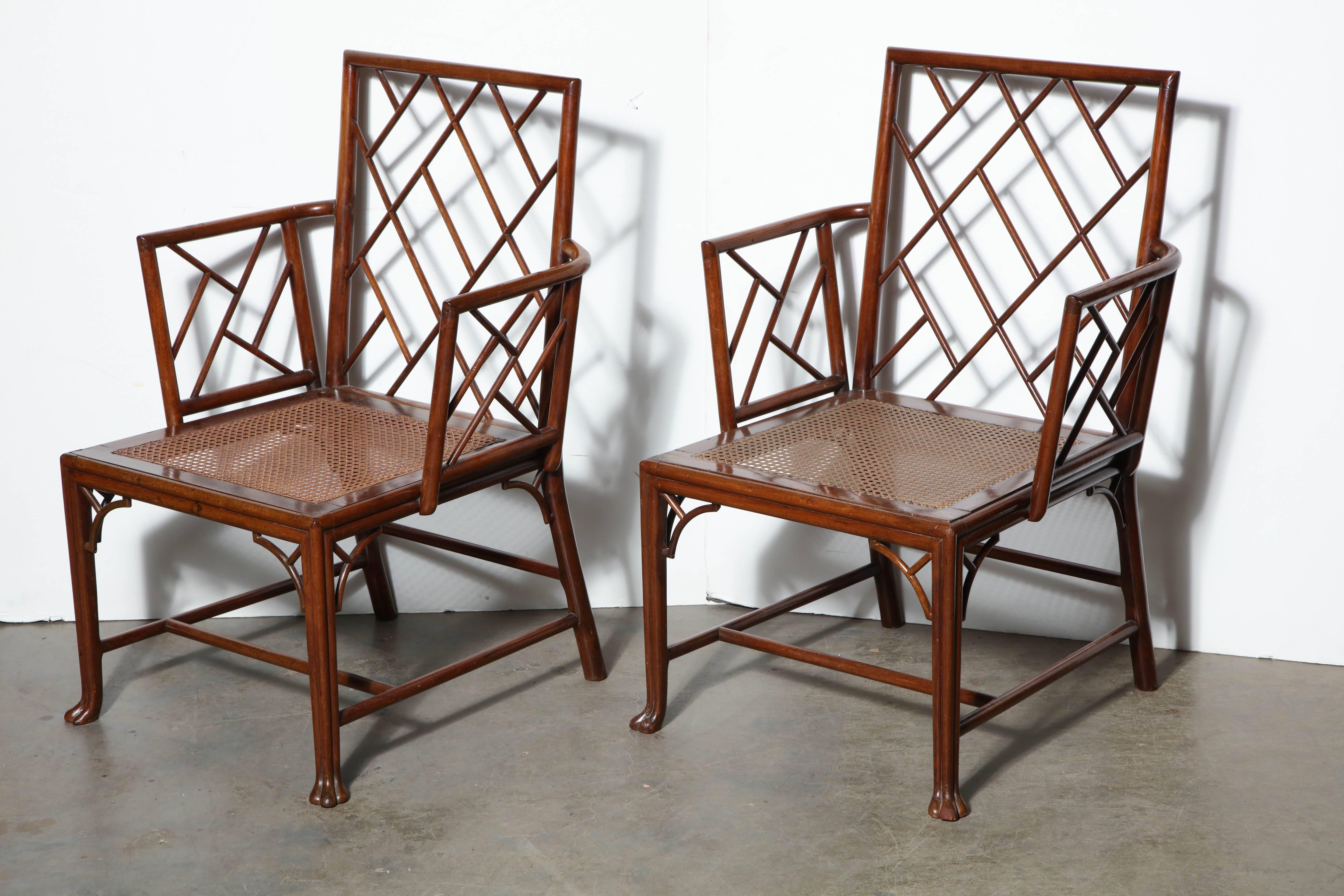 Pair of George III Padouk wood caned seat cockpen armchairs with pierced corner brackets, cluster column legs and paw feet.