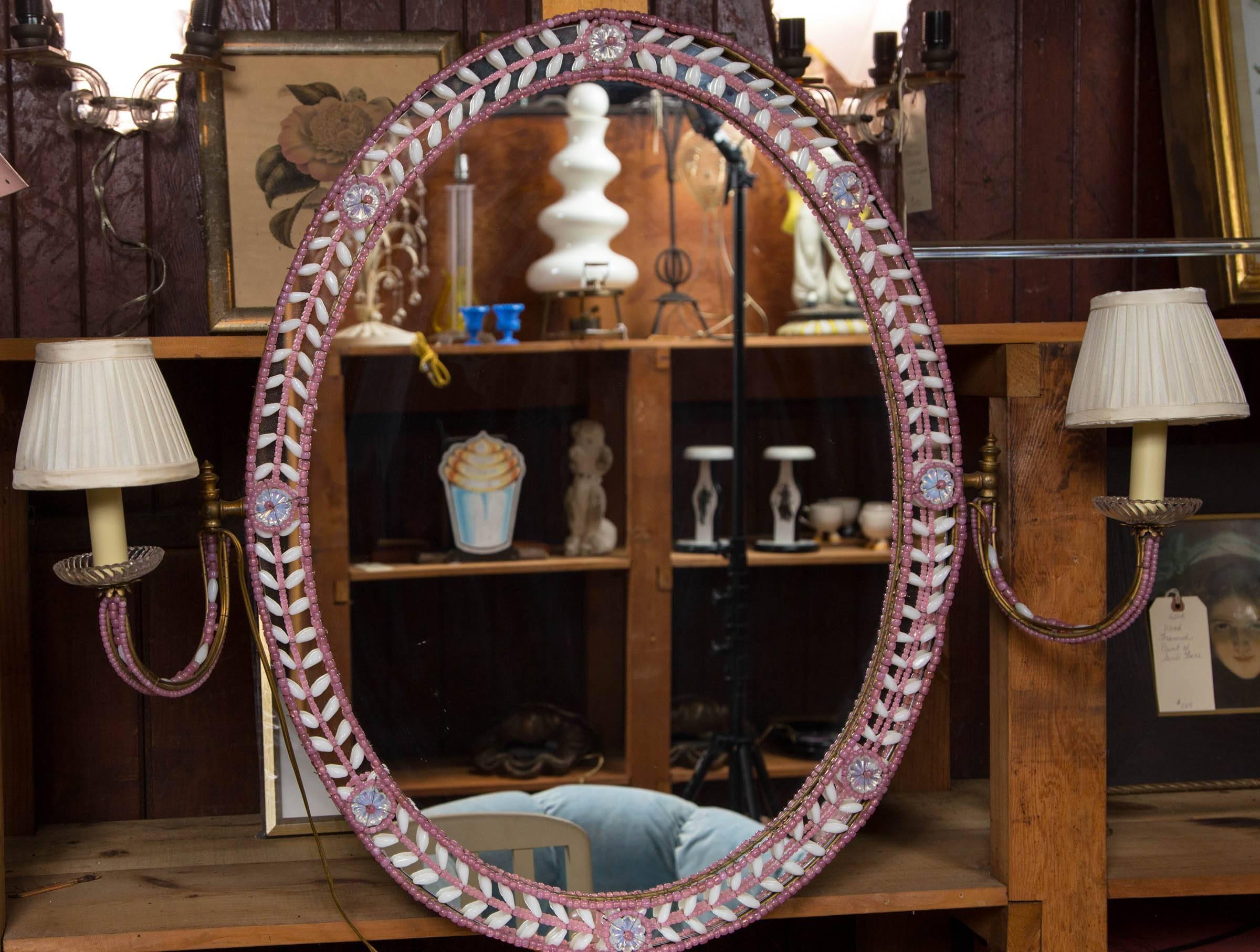 French pink and white glass beaded oval mirror and attached sconces.
37 inched wide with existing shades.