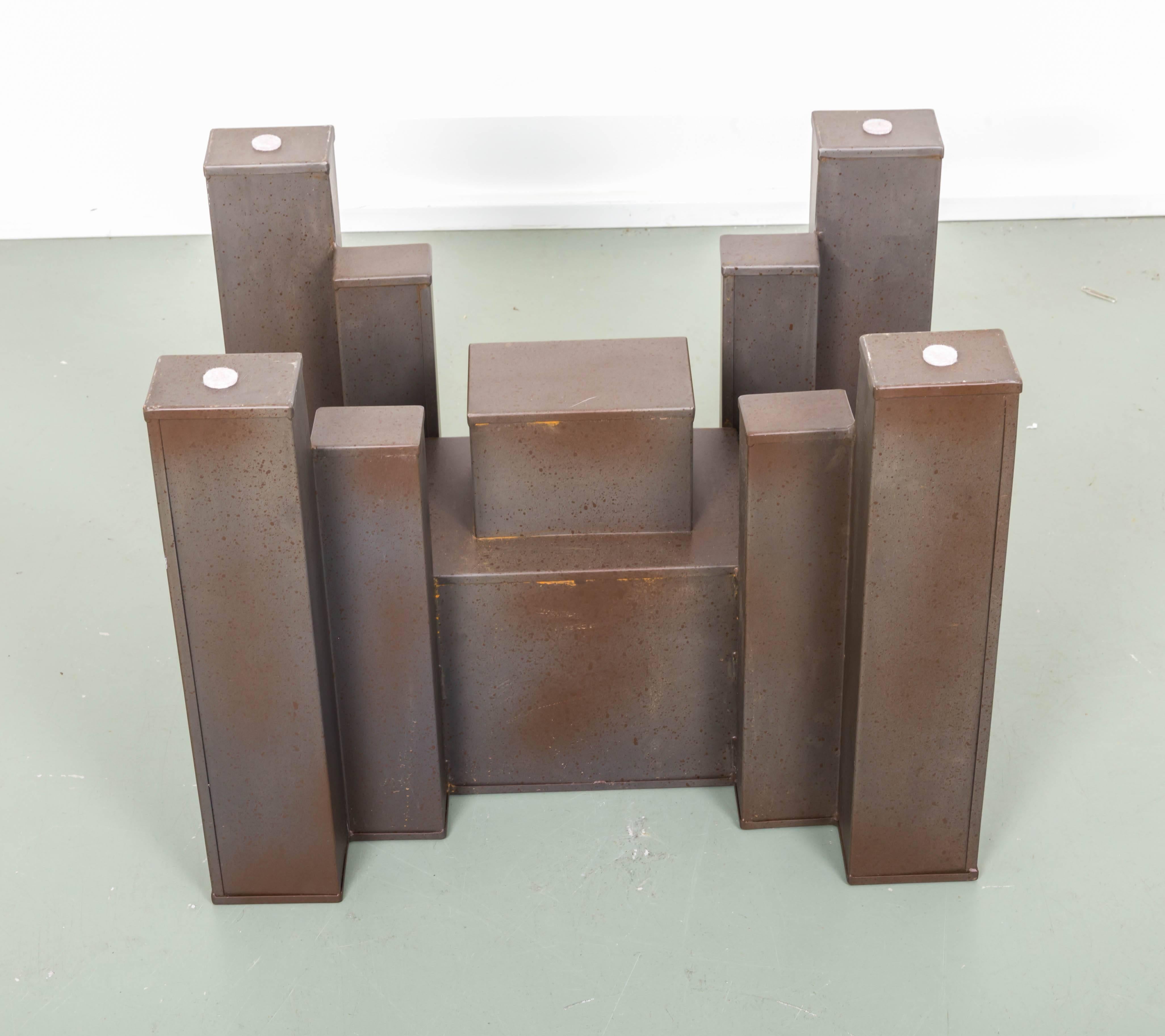 Large steel block in various sizes supporting glass top to create dramatic console table.
 