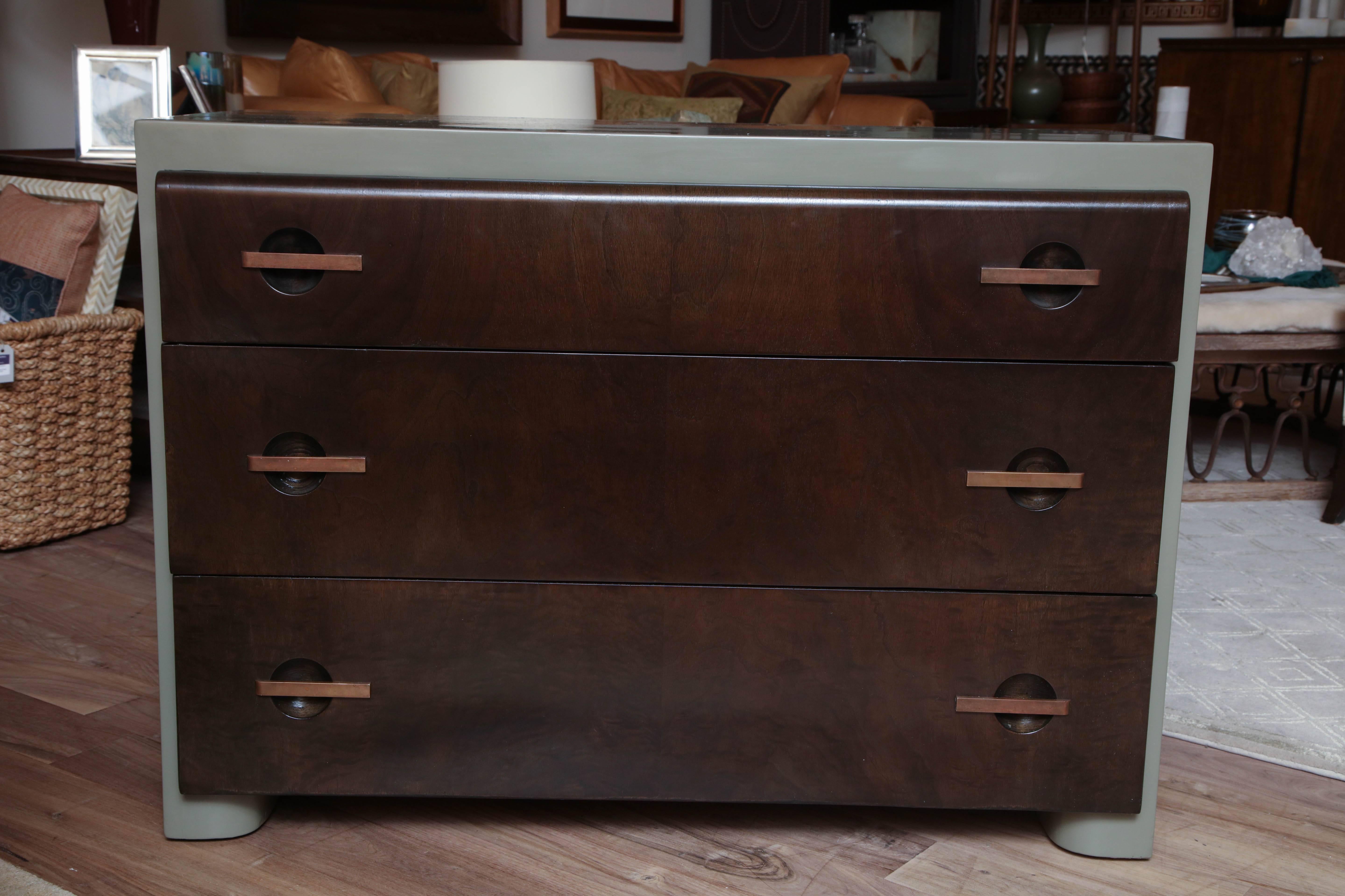 Three-drawer Art Deco dresser in the manner of Gilbert Rohde, circa 1940. Refinished with an opaque khaki lacquered case and amber drawer fronts.
