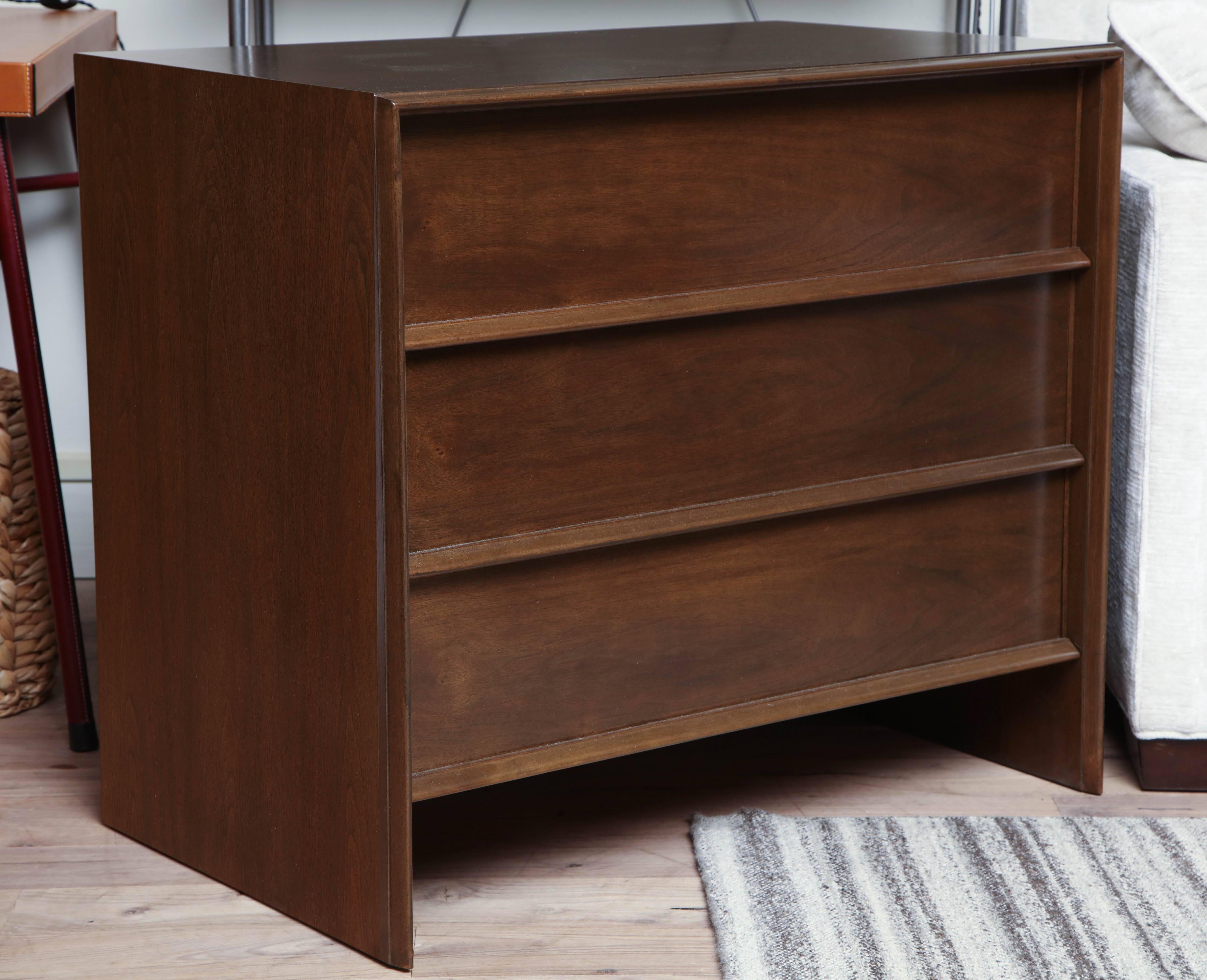 Pair of three-drawer chests or large nightstands with translucent medium walnut finish, circa 1950. In the manner of T.H. Robsjohn-Gibbings.