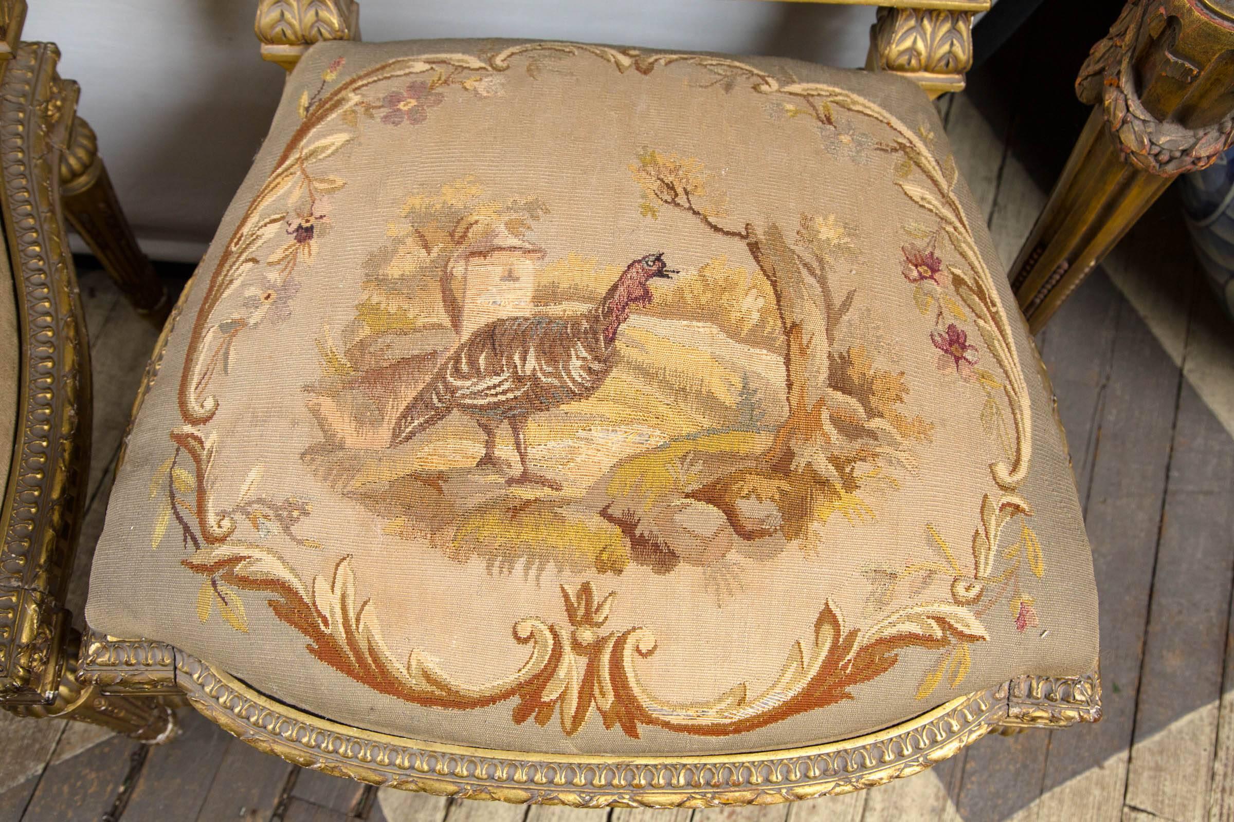 The pair of carved and giltwood frames. Deeply carved with bell flowers and gardrooning. The
needle point seats and backs hand done with images within cartouche. One depicting a maiden with a basket and stick, and a duck on the seat. The other