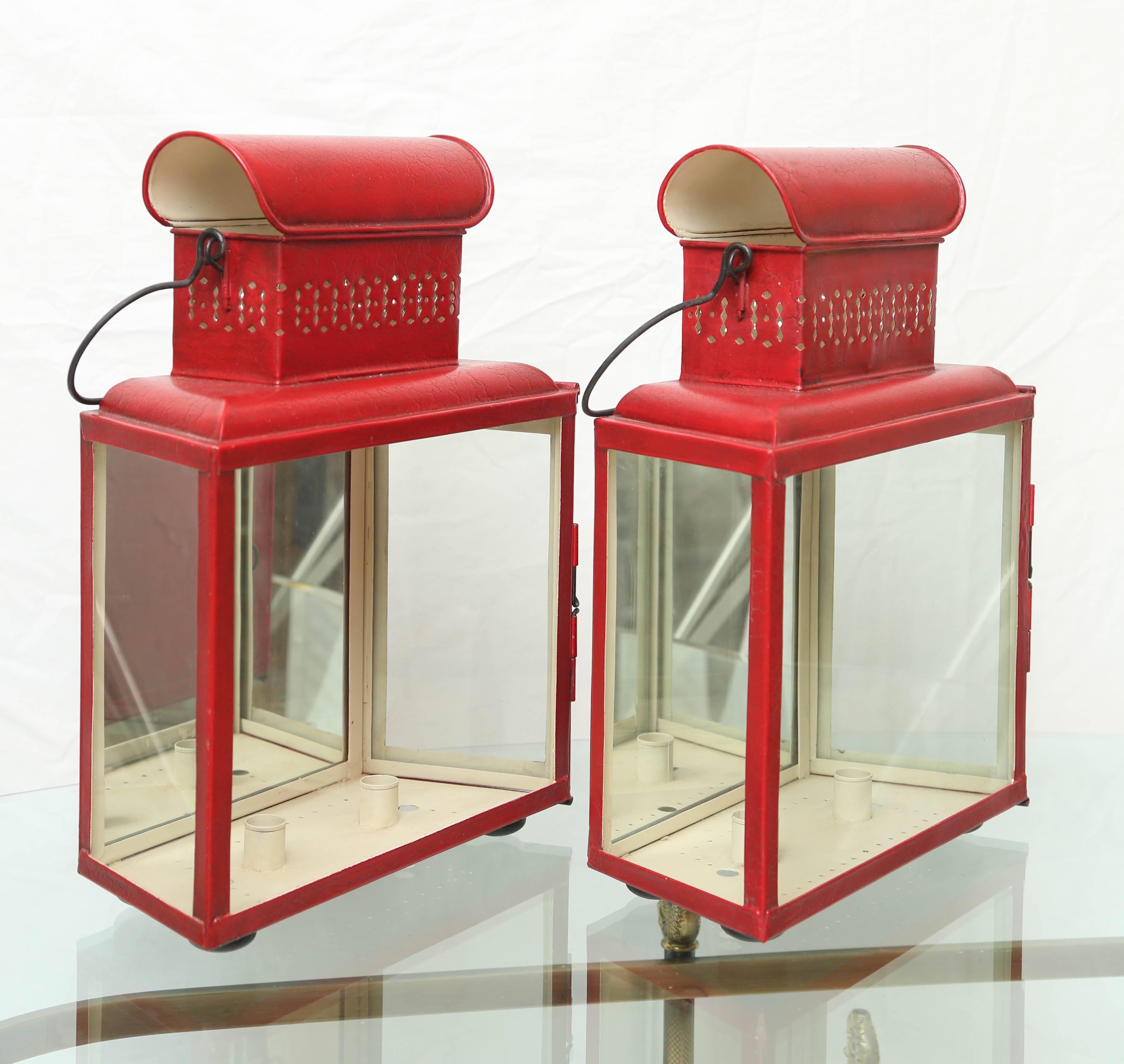 Striking pair of red metal lanterns with mirrored backs. Can sit on table or hang on wall. Non-electrified.