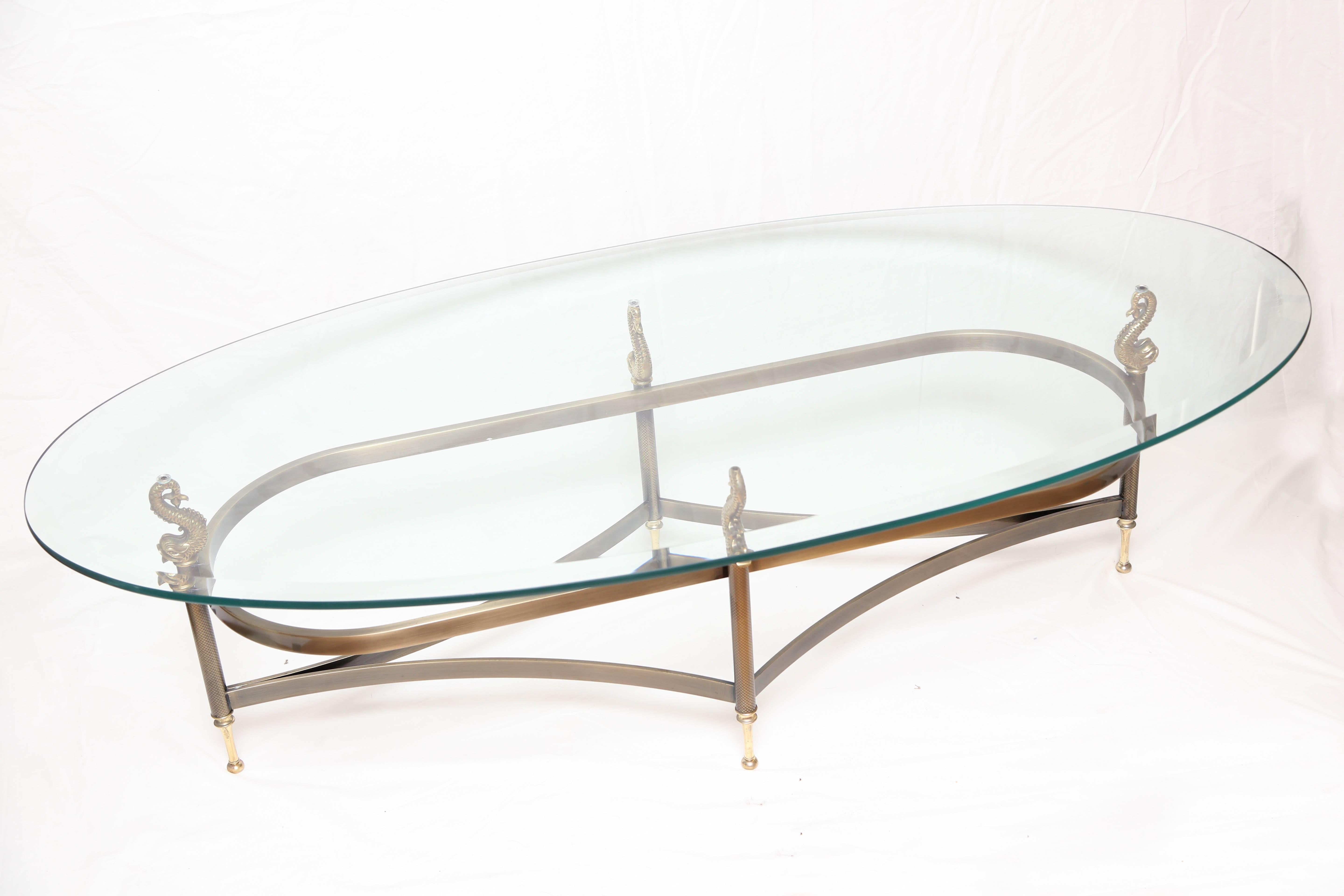 Oval brass base coffee table with four Koi fish supporting the glass top by Design Institute of America.