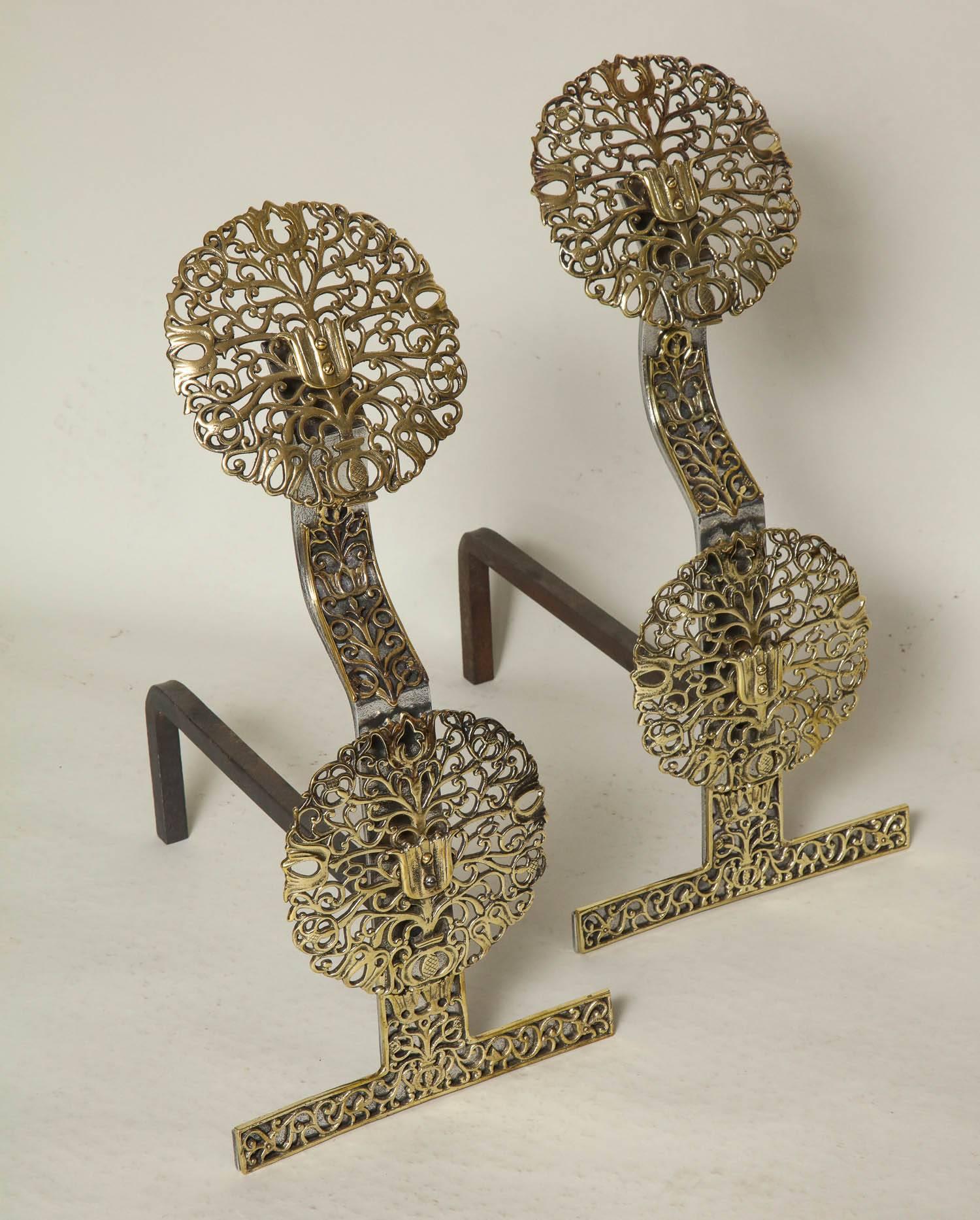 Fine pair of English Arts & Crafts andirons having pierced brass filigree finials and bosses and applied pierced brass mounts reminiscent of the tree of life.
