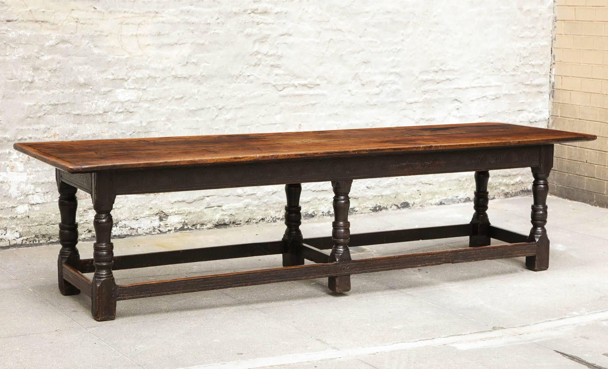 Fine 17th century welsh oak refectory table, the three plank top with breadboard ends over six-legged base, the apron with lunette carved apron, over balustrade turned legs joined by molded box stretchers, the whole with exceptional patina and in