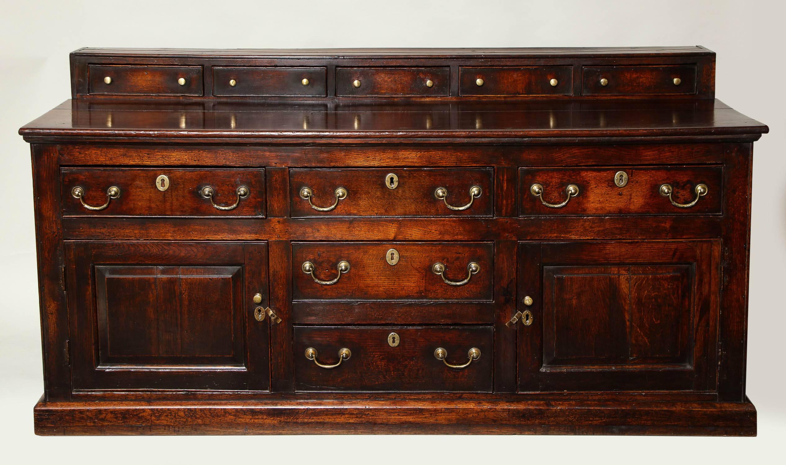 Very good 18th century Welsh oak low dresser with five spice drawers over raised panel sides and cupboard doors with central row of drawers, standing on plinth molded base and possessing a warm, rich patina and exceptional color.