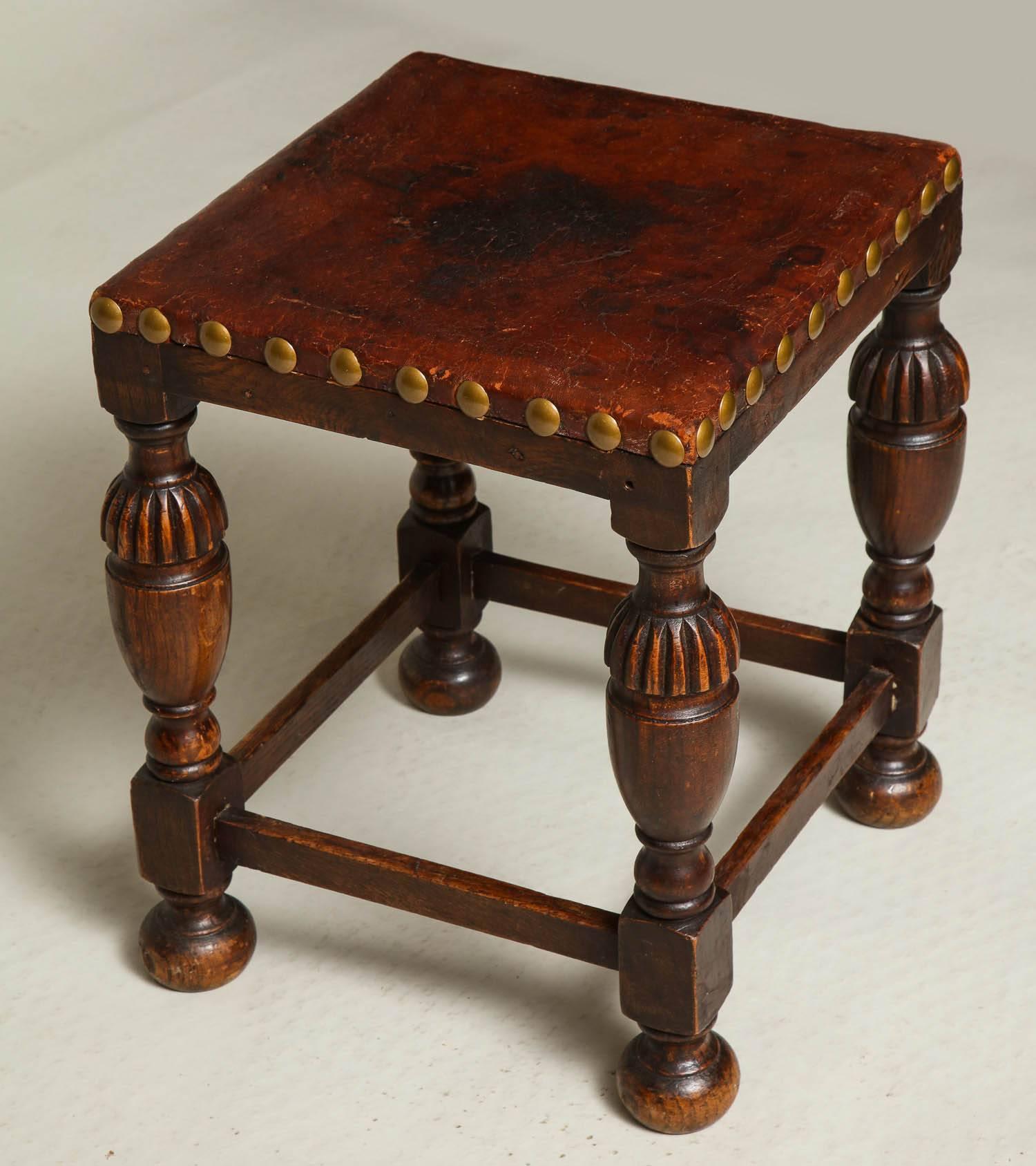 English oak and leather Arts & Crafts stool having thick tanned leather seat with over scale brass studs, over 