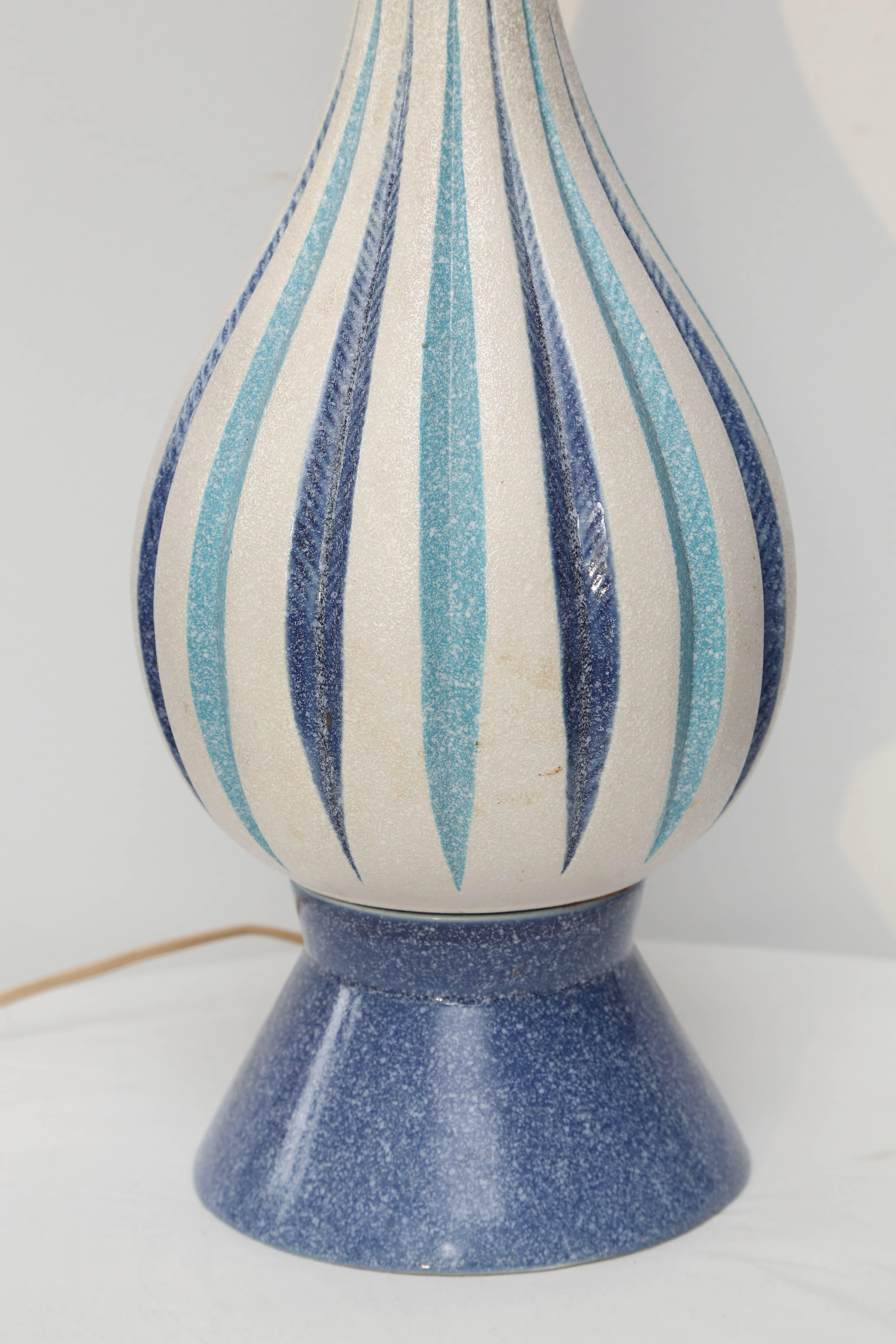 Amusante lampe en céramique bleue avec des accents en bois.