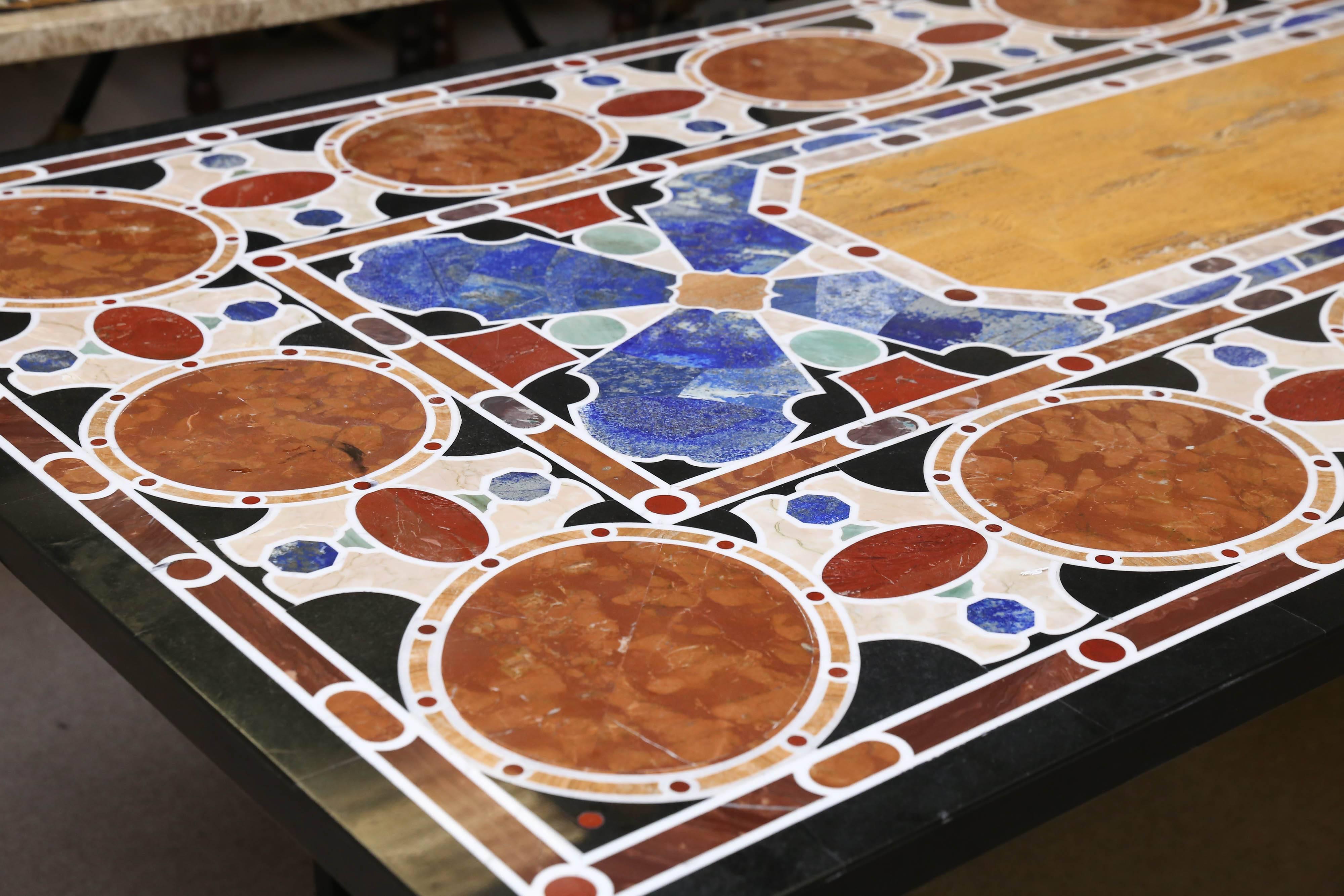 The black marble-top is inlaid with large quantity of semi-precious stones lapis-lazuli and other rare stones. The surface is almost scratch proof. Hand-forged heavy wrought iron frame support the tabletop.